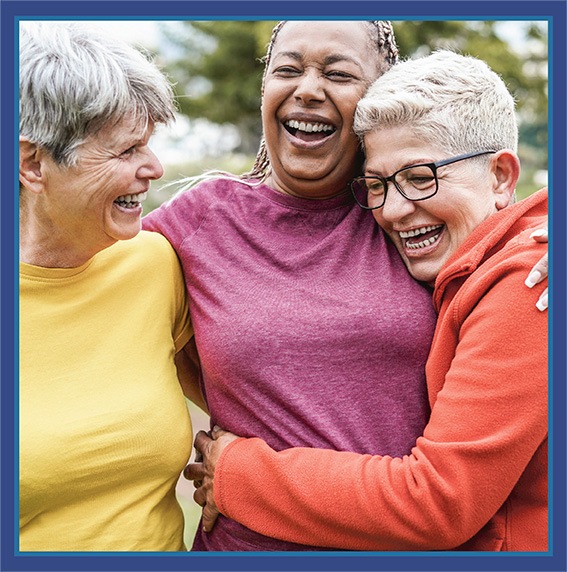 Three women smiling and hugging.