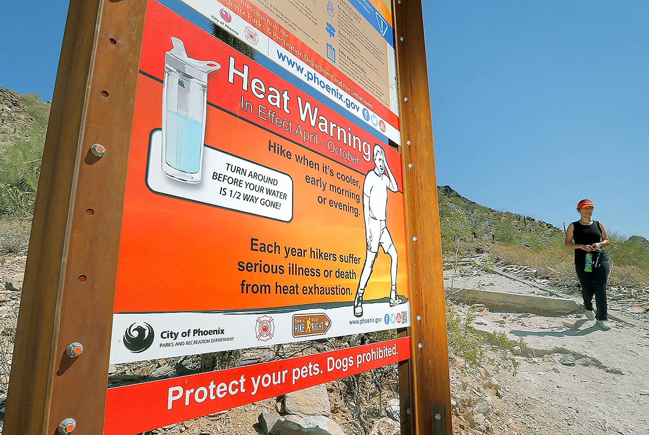 Signs warning of extreme heat, on a trailhead Wednesday at Piestewa Peak in Phoenix.