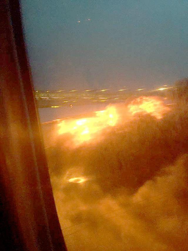 This image provided by Lee Bee Yee shows an engine on fire on a Singapore Airlines flight on Monday. A Singapore Airlines statement said the Boeing 777-300ER was on its way to Milan when it turned back “following an engine oil warning message.” (Lee Bee Yee via AP)