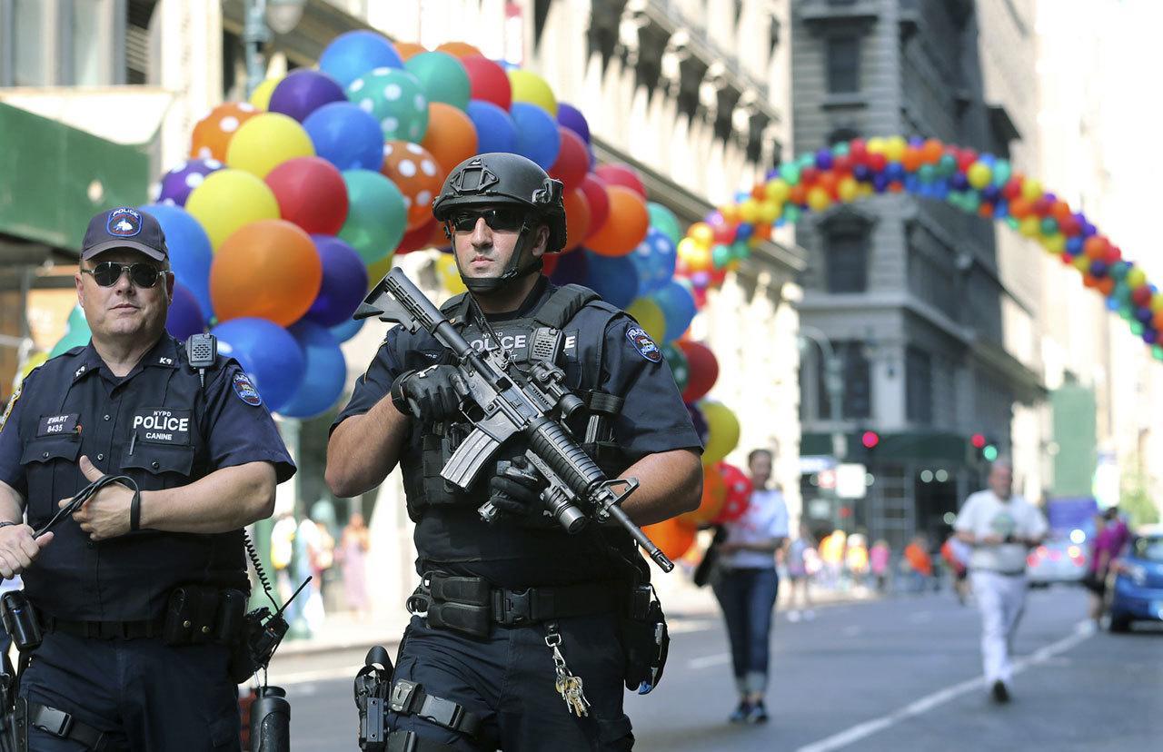 Police officers walk along the street near the parade route of the New York City Pride Parade on Sunday in New York City. A year after New York City’s storied gay pride parade celebrated a high point with the legalization of gay marriage nationwide, the atmosphere this year couldn’t be more different. Parades in New York and other major cities Sunday will feature increased security, anti-violence messages and tributes to those killed in this month’s massacre at a gay nightclub in Florida. (Mel Evans / Associated Press)