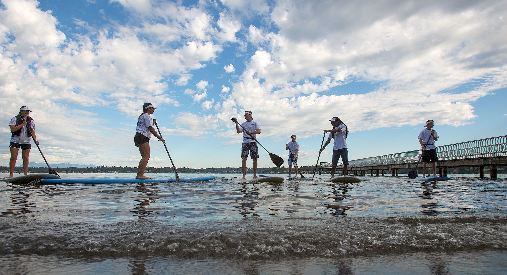 Paddle Broz employees try out new stand-up paddleboards at Lundeen Park on Monday in Lake Stevens. The new vendor at the park will provide kayak and stand-up paddle board rentals. (Andy Bronson / The Herald)