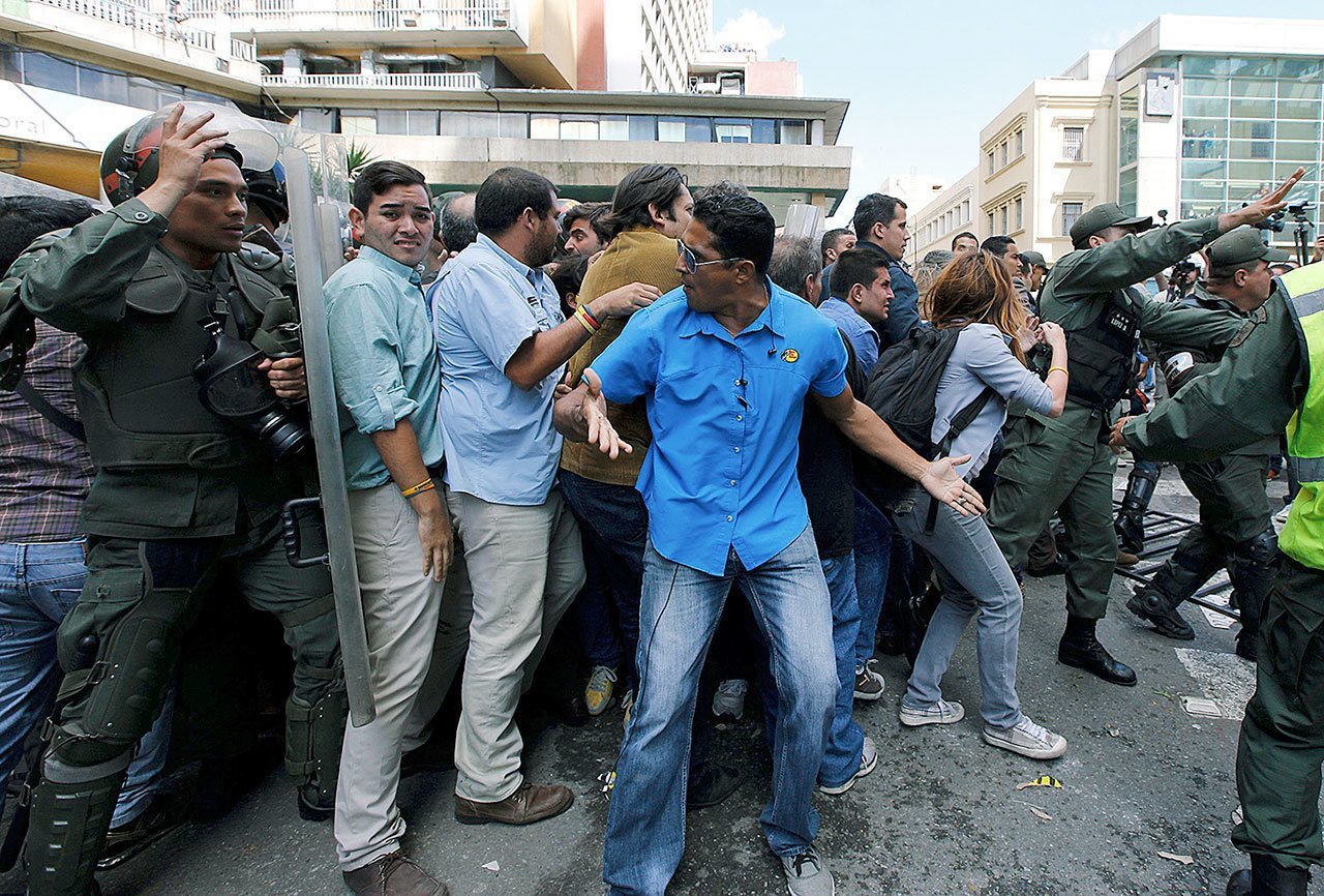Opposition protesters are made to leave the entrance to the headquarters of the National Electoral Council by Bolivarian National Guards in Caracas, Venezuela, on June 9. Opposition members were turned back from the headquarters of Venezuela’s electoral body where the group attempted to enter to demand the government allow it to pursue a recall referendum against President Nicolas Maduro. (Ariana Cubillos / Associated Press)