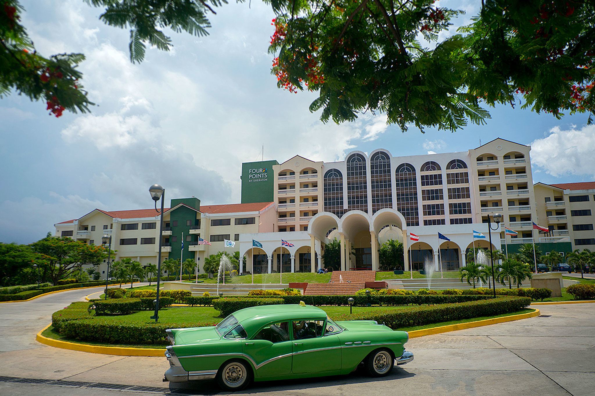 A vintage car passes in front of the Four Points by Sheraton hotel in Havana on Tuesday. American hotel giant Starwood has begun managing this hotel run by the Cuban military. (Associated Press / Ramon Espinosa)