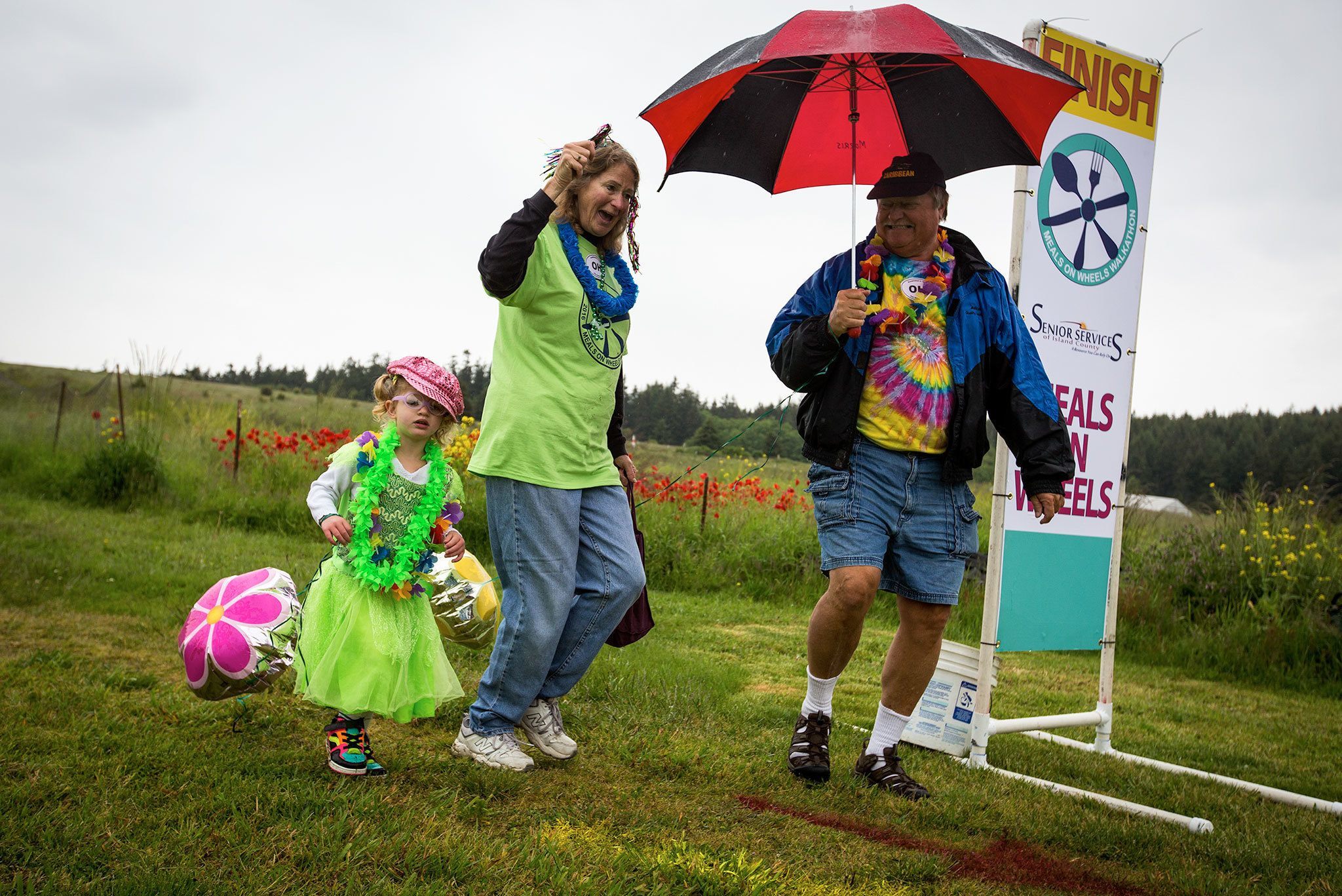 Eric and Wendy Geyer cross the finish line with their 3-year-old granddaughter, Bailee Furness, during the Meals on Wheels Walkathon and fundraiser on May 21 on Whidbey Island. (Daniella Beccaria / For the Herald)
