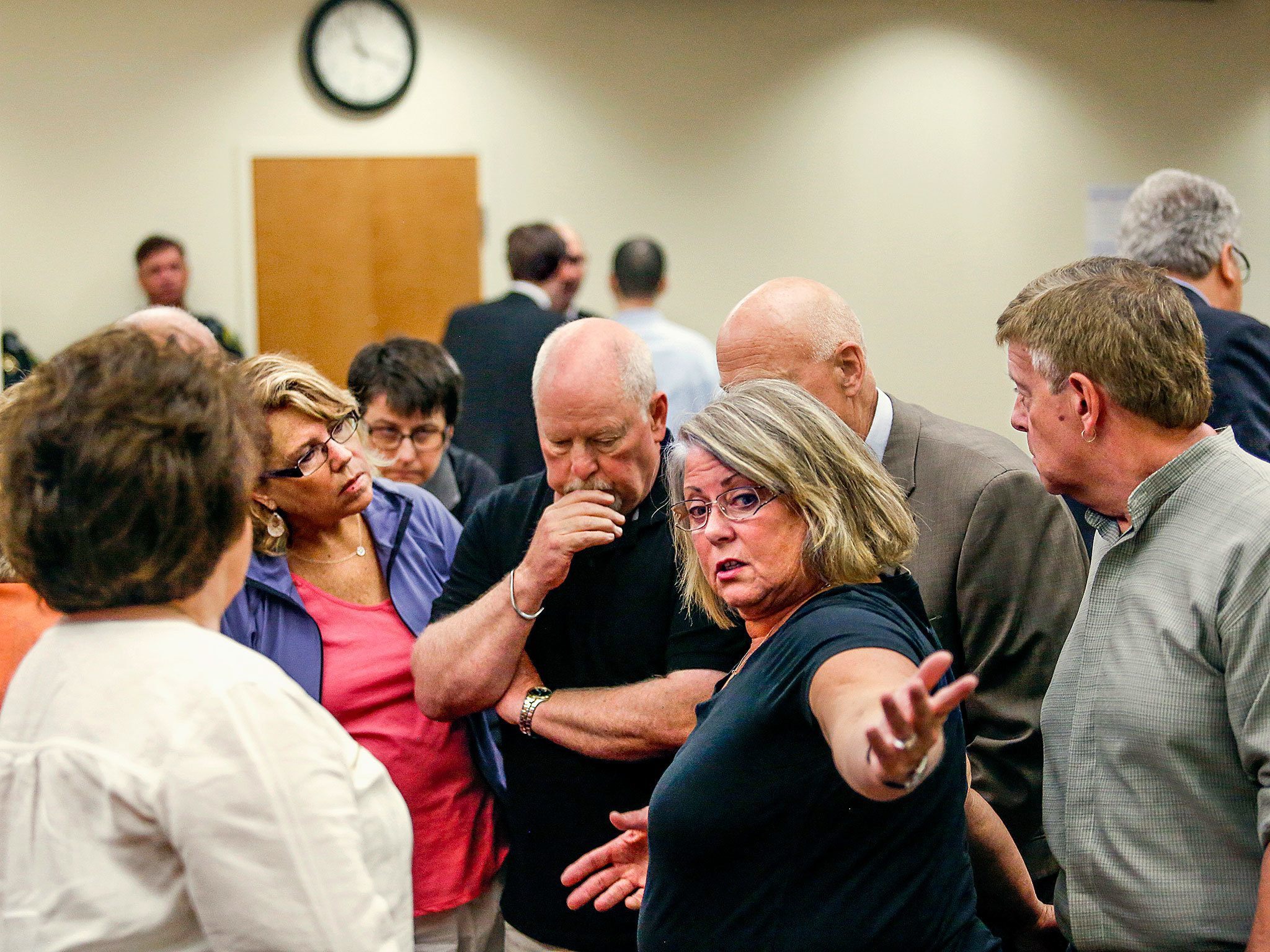 Denise Webber (center), mother of Rachel Burkheimer, gathers with family members and Snohomish County Prosecutor Mark Roe in response to events surrounding the jury, late Wednesday morning, as the trial for John Alan Whitaker appeared to be in jeopardy. (Dan Bates / The Herald)