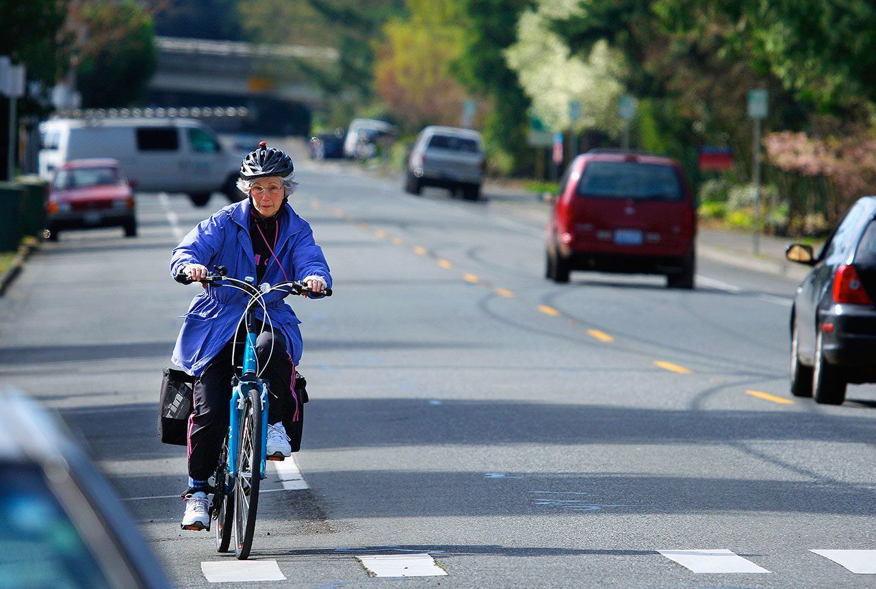 Gayla Shoemake, a member of Edmonds United Methodist Church, rides her bicycle down Third Avenue towards downtown Edmonds in 2013. (Herald file)