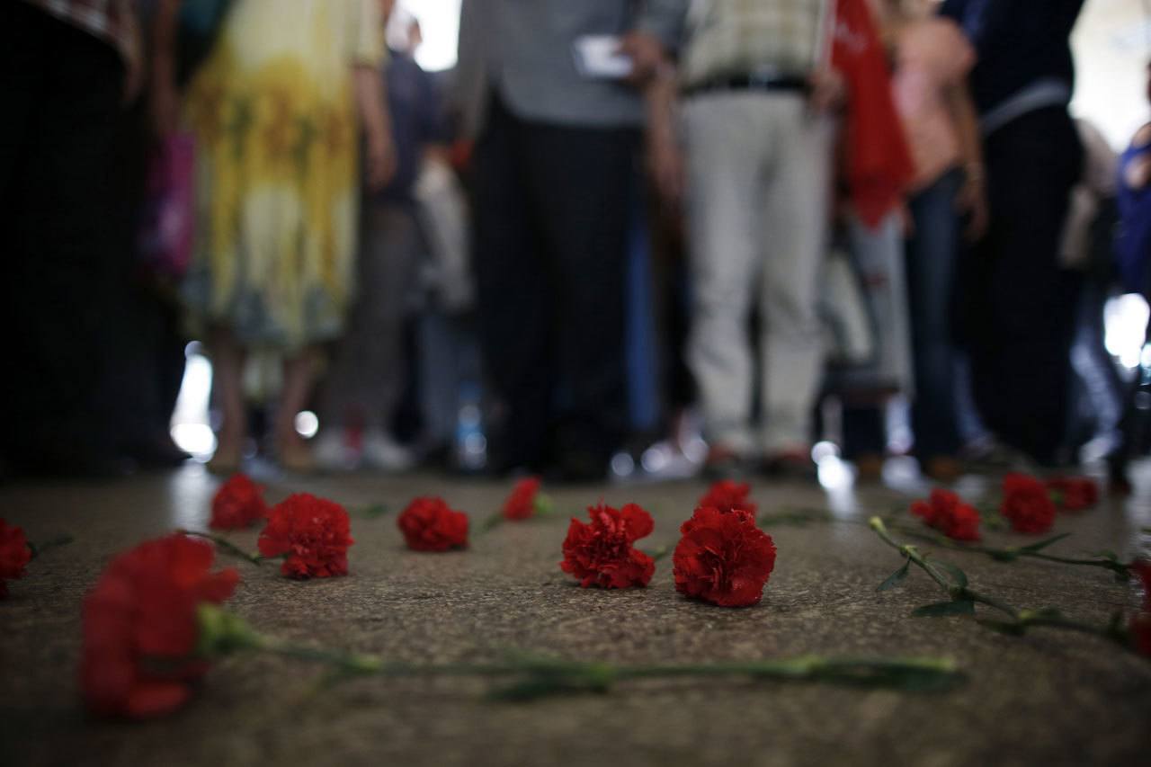 Colleagues leave carnations for Erol Eskisoy and Ali Zulfukar Yorulmaz, two taxi drivers killed in Tuesday’s blasts at the entrance of Ataturk Airport in Istanbul, on Thursday. A senior Turkish official on Thursday identified the Istanbul airport attackers as a Russian, Uzbek and Kyrgyz national hours after police carried out sweeping raids across the city looking for Islamic State suspects. (Emrah Gurel / Associated Press)