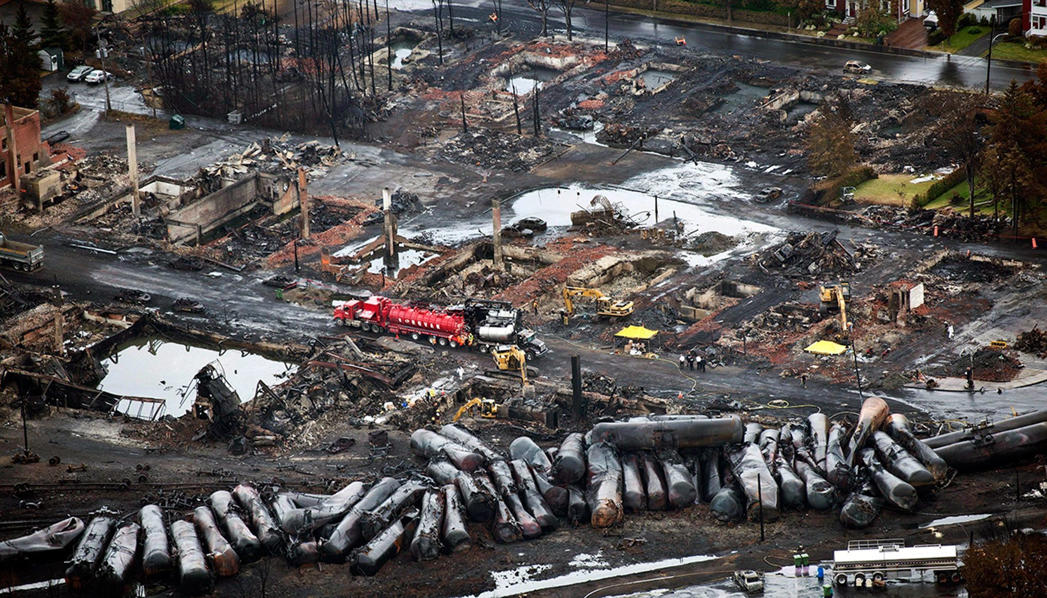 Workers comb through debris in 2013 after an oil train derailed and exploded in Lac-Megantic, Quebec, killing 47 people. (Paul Chiasson/The Canadian Press)