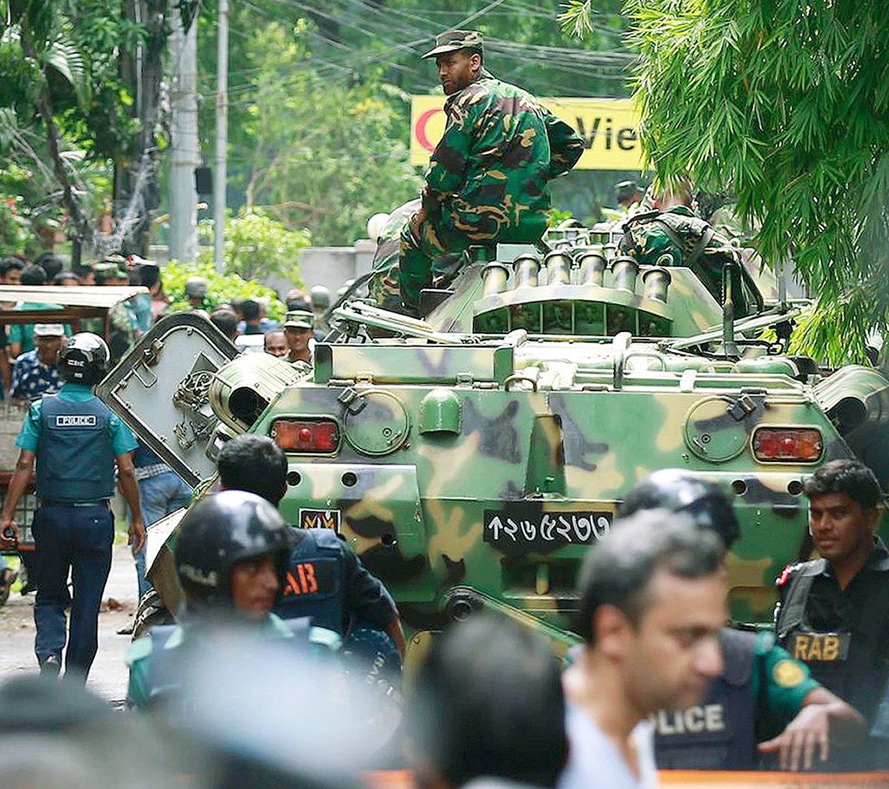 Bangladeshi soldiers and security personnel sit on armored vehicles as they cordon off an area near a restaurant popular with foreigners after heavily armed militants took dozens of hostages in the Bangladeshi capital of Dhaka on Saturday. (AP Photo)