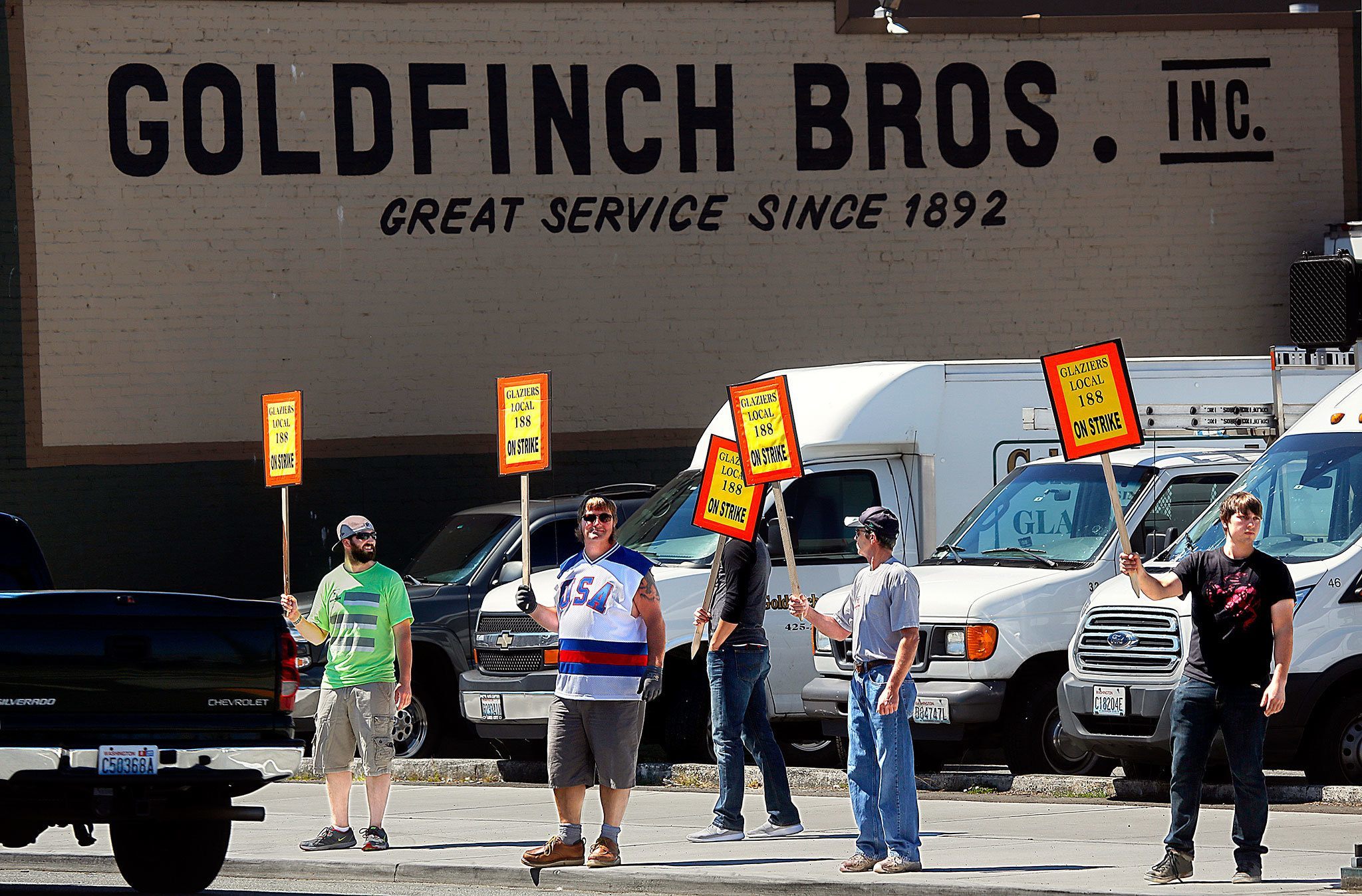 Picket Captain, Mike Marley (left) Jesse Stanton (right) and Tony Unferdorfer (second from right) as well as two more Glaziers and Glassworkers Local 188 picketers prefering anonymity, picket along Rucker Avenue outside Goldfinch Brothers in Everett Wednesday. Glasiers and Glassworkers is out of Seattle, Marley said, and the union, which covers Washington, Idaho and Alaska, began picketing 13 shops Tuesday, including some others in Snohomish County. (Dan Bates / The Herald)