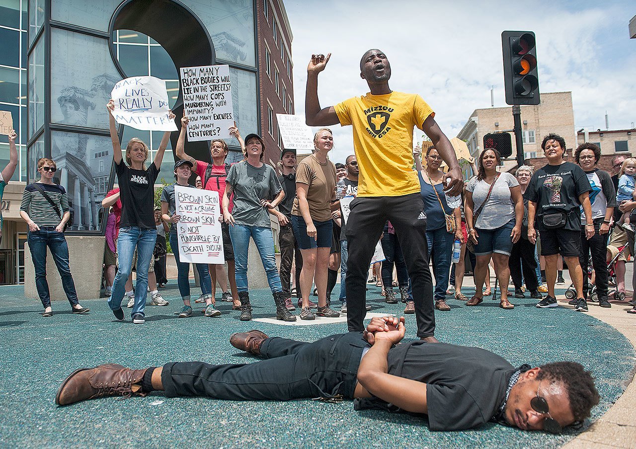 Ola Aromaye (center), chants Thursday in Columbia, Missouri, as he and Jamie Davis (bottom), protest the shooting this week in Baton Rouge, Louisiana, of Alton Sterling. (Daniel Brenner/Columbia Daily Tribune)
