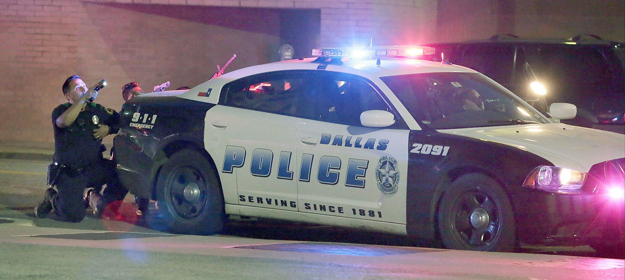 Dallas police respond late Thursday after shots were fired during a protest over recent fatal shootings by police in Louisiana and Minnesota. Snipers opened fire on police officers during protests, killing four and wounding seven. (Maria R. Olivas/The Dallas Morning News via AP)