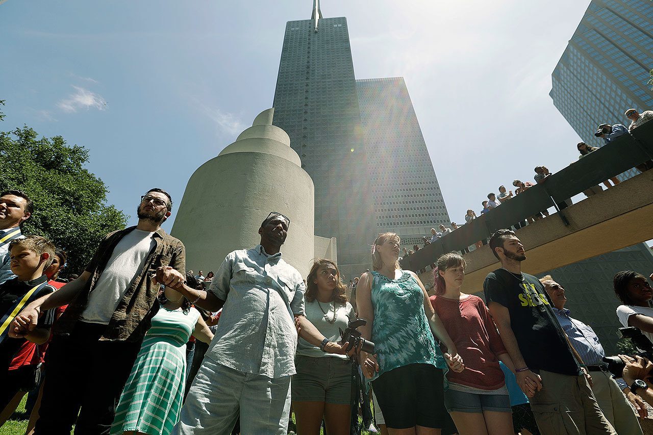 People join hands at a prayer vigil at Thanksgiving Square on Friday in Dallas. (AP Photo/Eric Gay)