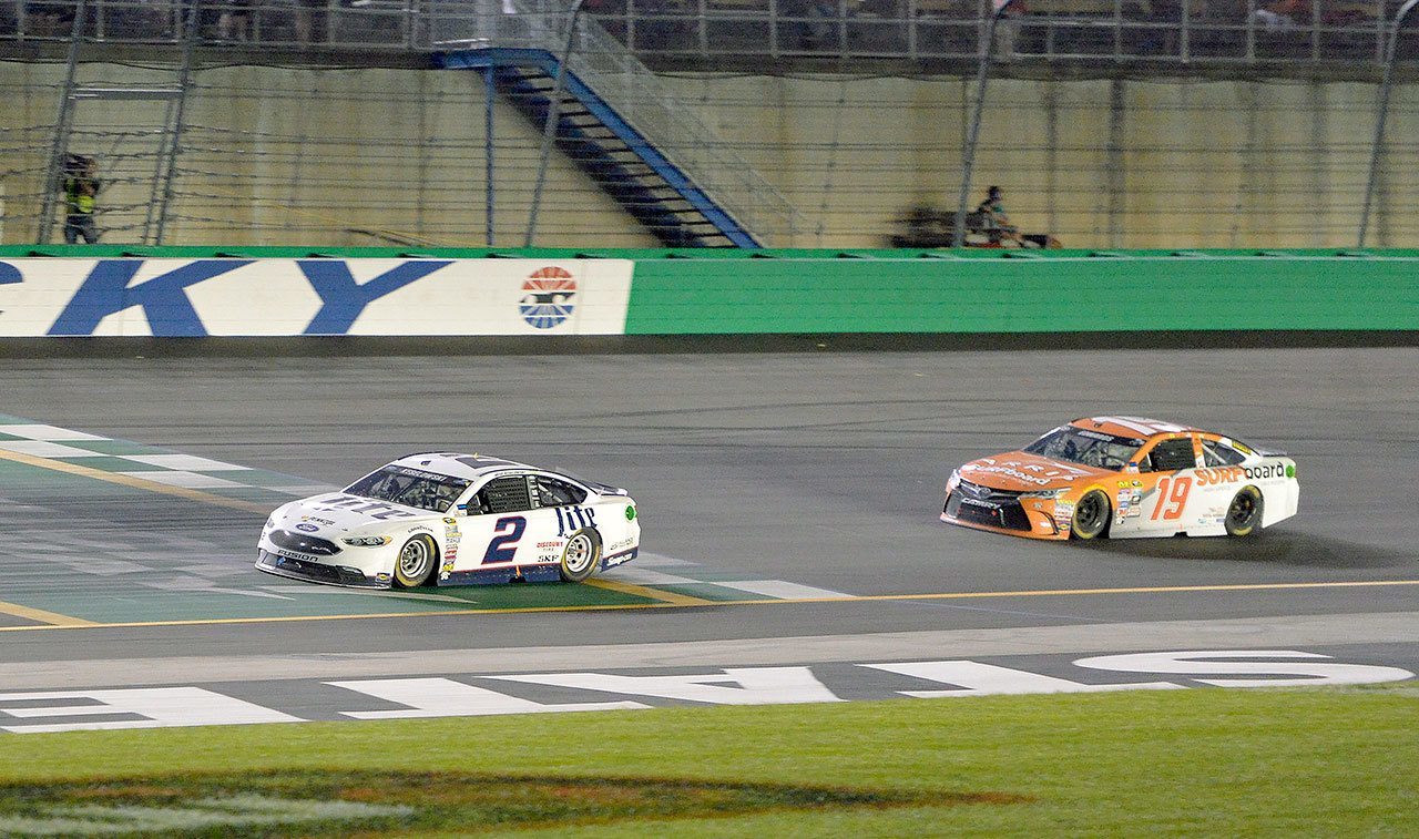 Brad Keselowski (2) crosses the finish line to win the NASCAR Sprint Cup Series race at Kentucky Speedway on Saturday in Sparta, Ky. At right is Carl Edwards, who finished second. (AP Photo/Timothy D. Easley)