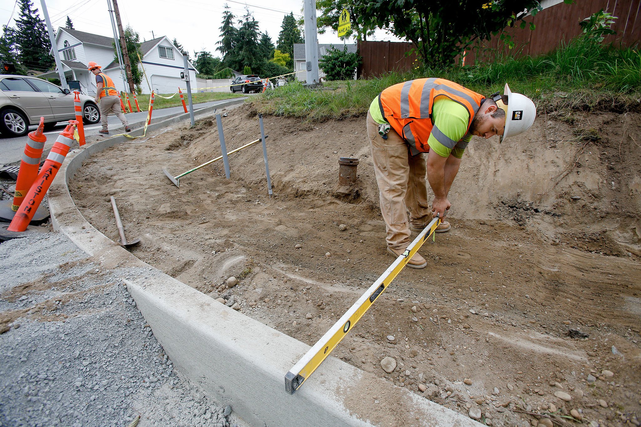 City of Everett Public Works’ Alfredo Aguirre checks the level and depth of excavation for a new ADA-compliant curb at the corner of Broadway and 52nd Street on Monday. (Andy Bronson / The Herald )