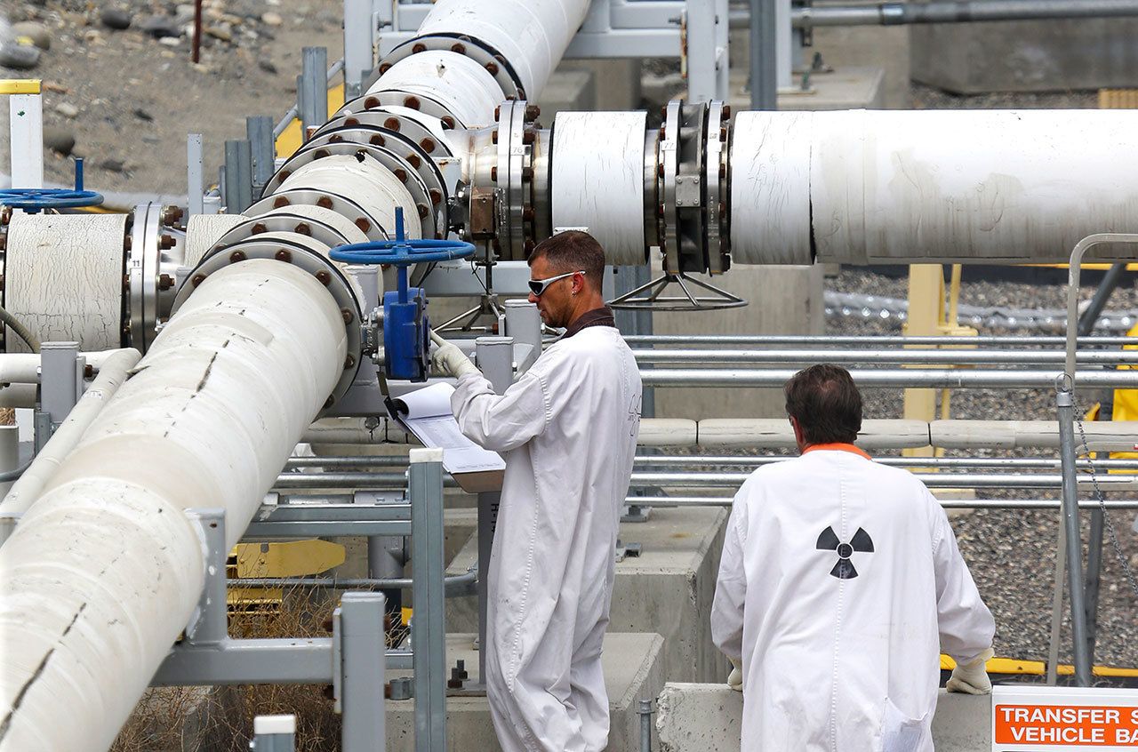 In this July 9, 2014, photo, workers wearing protective clothing and footwear inspect a valve at the “C” tank farm on the Hanford Nuclear Reservation near Richland. (AP Photo/Ted S. Warren, File)