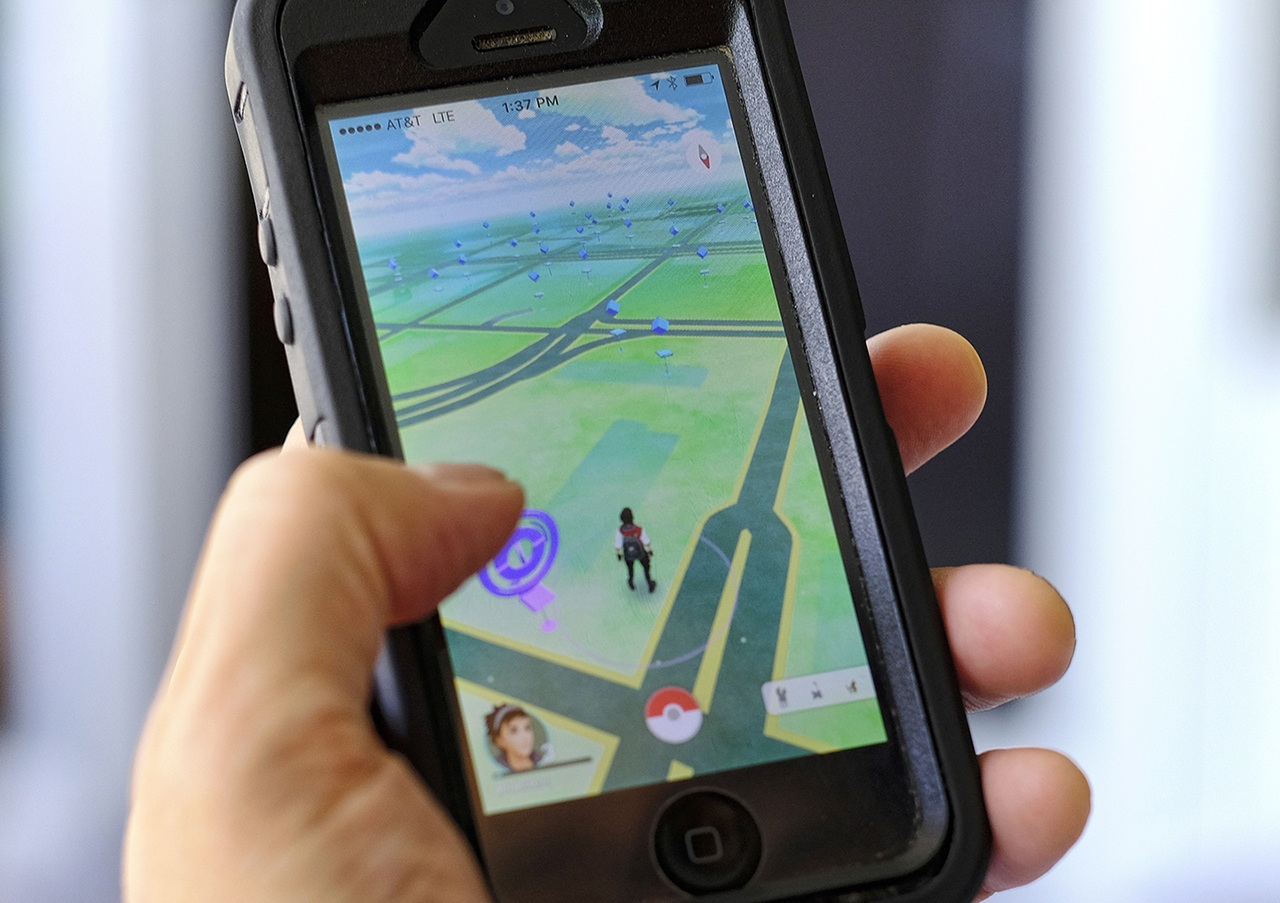 Just days after being made available in the U.S., the mobile game Pokemon Go has jumped to become the top-grossing app in the App Store. And players have reported wiping out in a variety of ways as they wander the real world, eyes glued to their smartphone screens, in search of digital monsters. (AP Photo/Richard Vogel)