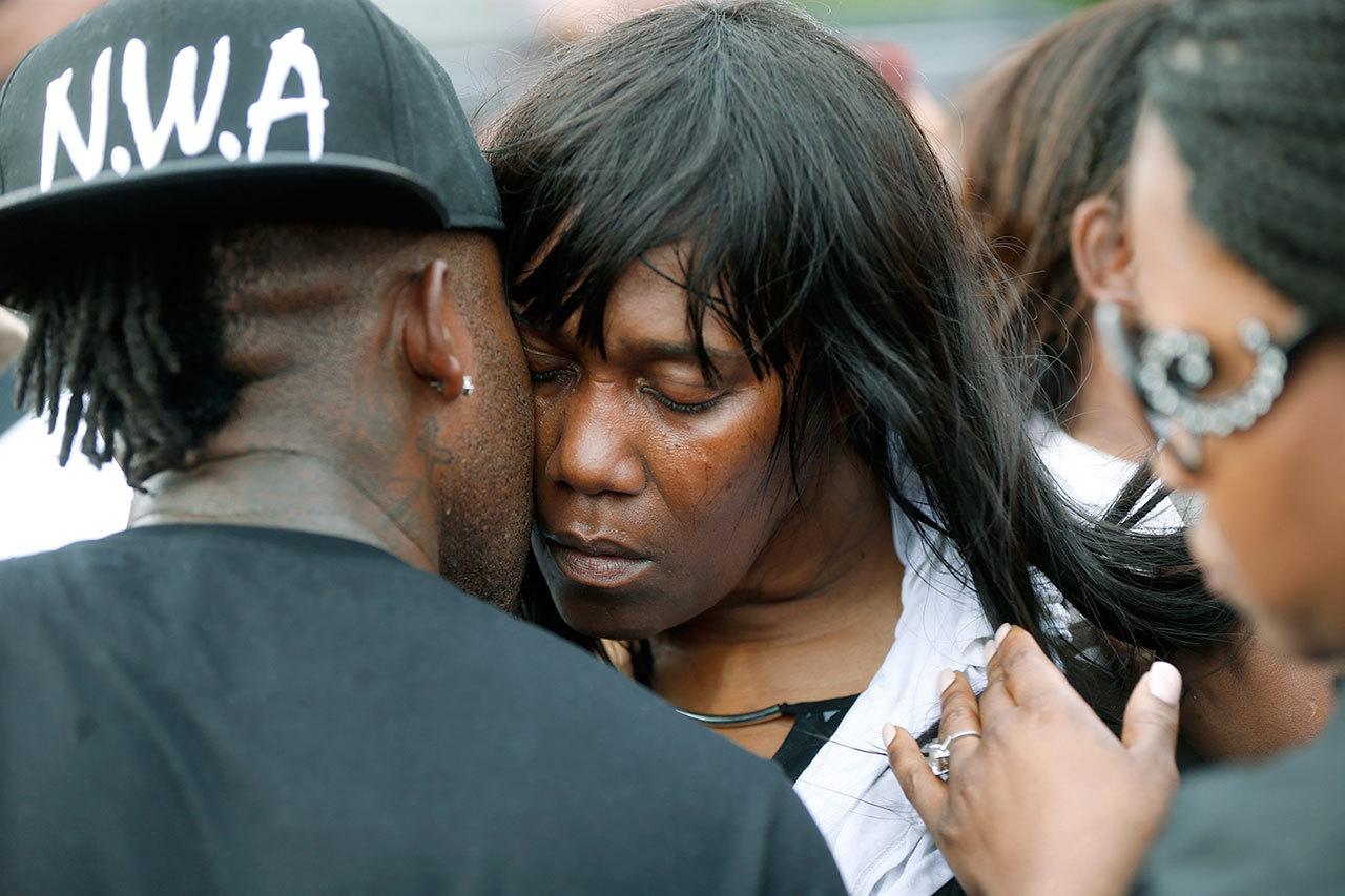 Sandra Sterling, aunt of Alton Sterling, is comforted at a vigil outside the Triple S convenience store in Baton Rouge, Louisiana, on Wednesday. Sterling, 37, was shot and killed outside the store by Baton Rouge police, where he was selling CDs. (AP Photo/Gerald Herbert)