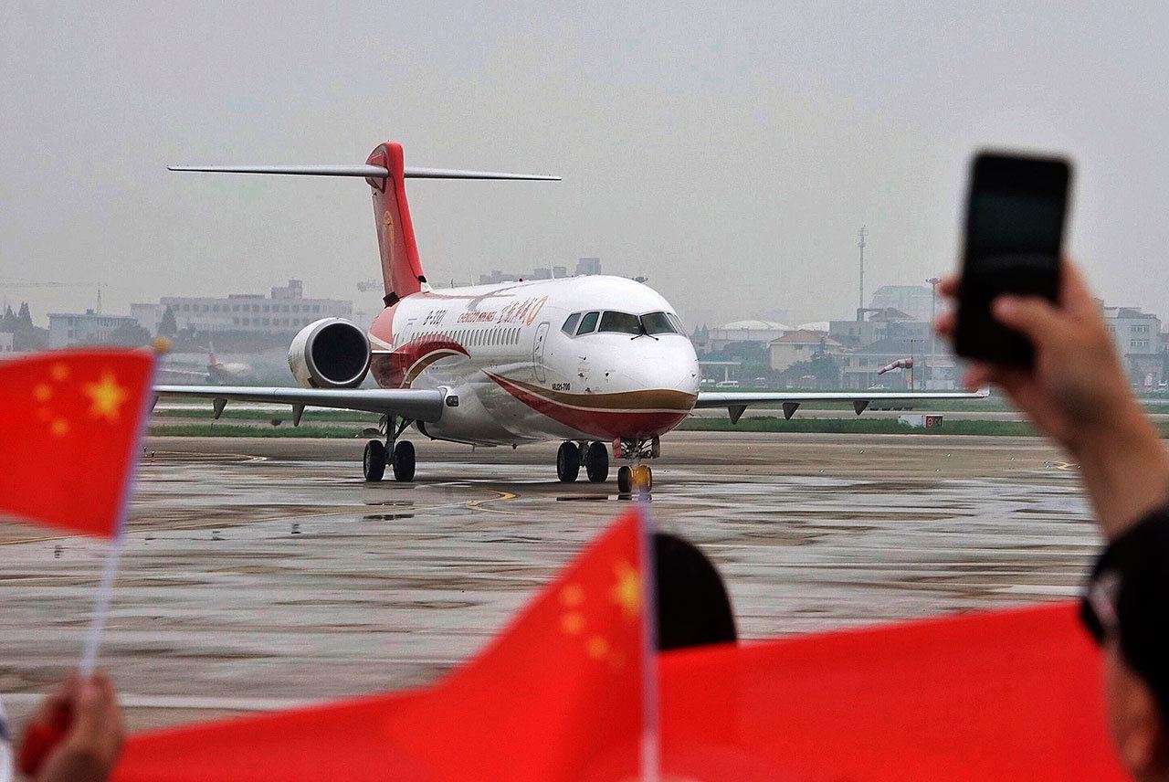 In this June 28, 2016, file photo, people wave Chinese flags and take photos as a Chengdu Airlines ARJ21-700 regional jet is taxied after landing at the Hongqiao Airport in Shanghai. China’s state-owned aircraft maker signed a deal to sell up to 60 of its new regional jets to a leasing company in a deal worth up to $2.3 billion. In a joint statement released late Monday, July 11, 2016, Commercial Aircraft Corp. said the agreement signed with China Aircraft Leasing includes a confirmed order for 30 ARJ21-700 jets and an option to buy 30 more. (Chinatopix)