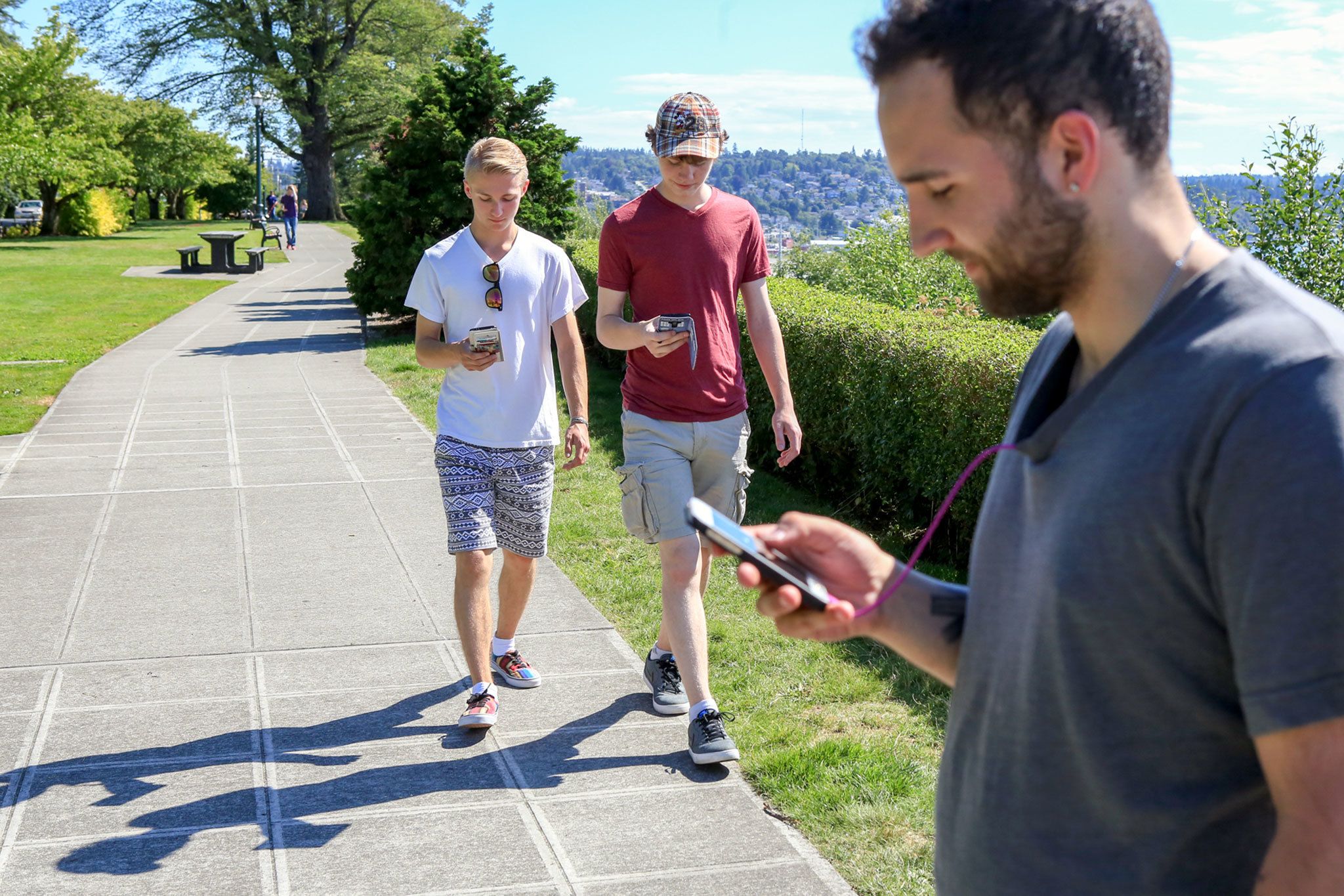 Kevin Clark / The Daily Herald                                Liam Smoody, Chandan Mercer and Trae Poplin work to ‘catch’em all’ at Grand Avenue Park in Everett.