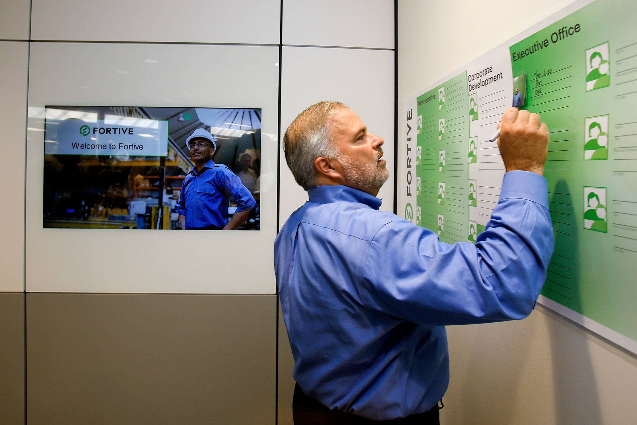 Fortive president and CEO James Lico puts his photo and name on a banner during the opening of the company’s new offices on Thursday in Everett. The companies under the Fortive umbrella had had total revenues of about $6.2 billion last year, big enough to earn the overall company a spot on Fortune 500’s annual list of largest U.S. corporations. (Andy Bronson / The Herald )