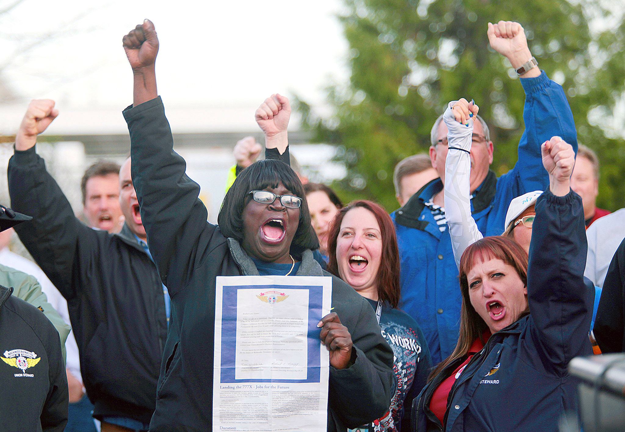 Machinist Stephanie Lloyd-Agnew holds up a contract while chanting “just say no,” with fellow machinists during a rally at the Everett Machinists Union Hall on November 11, 2013. (Mark Mulligan / The Herald)
