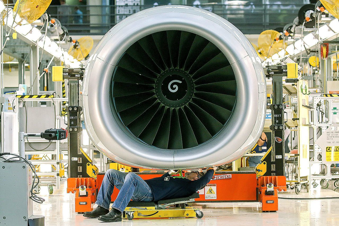 A Boeing employee works on an engine at the company’s Renton 737 plant in March. (Kevin Clark / The Herald)