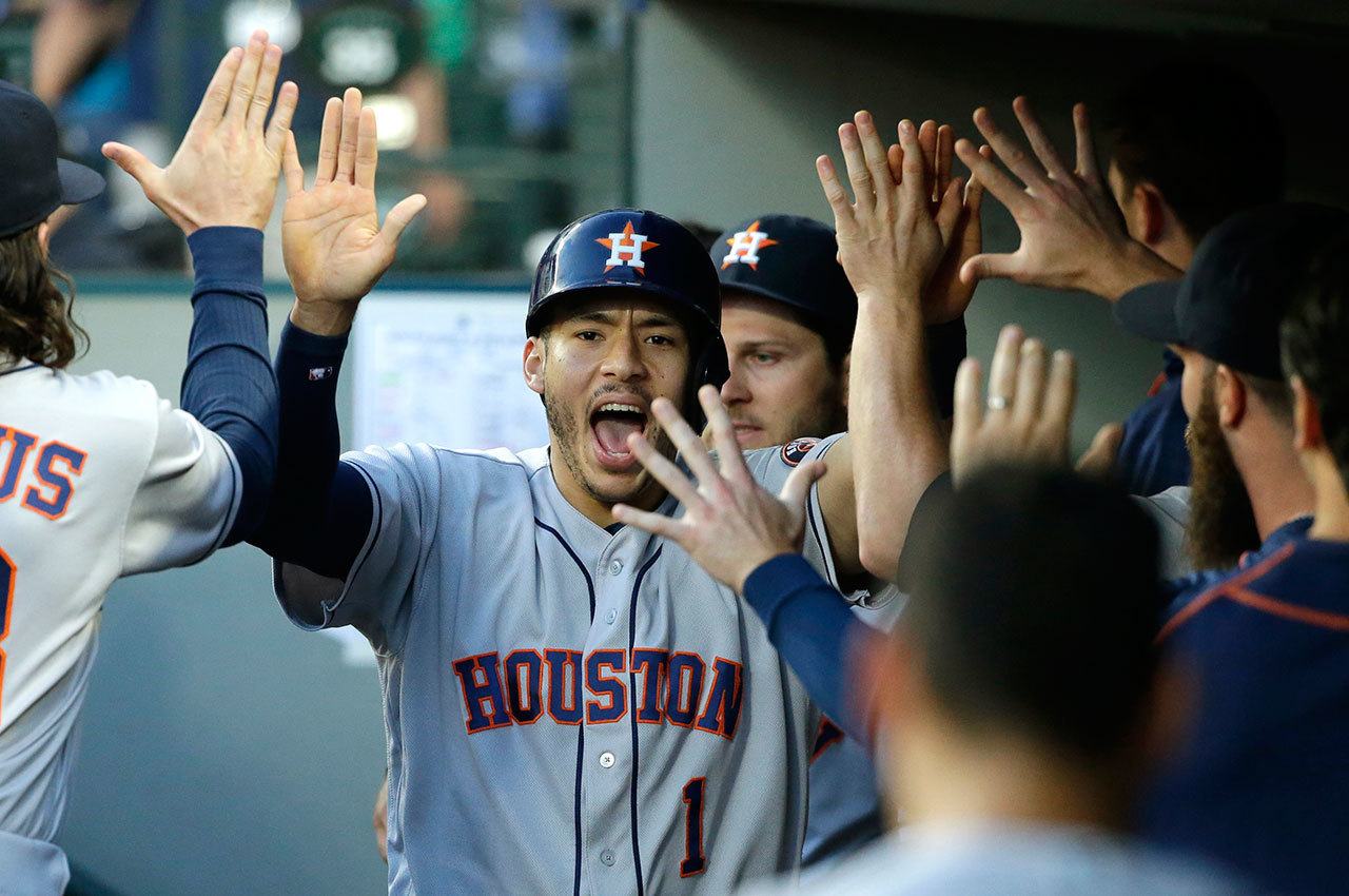 Houston Astros’ Carlos Correa is greeted in the dugout after he scored on a wild pitch by Seattle Mariners starting pitcher James Paxton during the fifth inning of Friday’s game. (AP Photo/Ted S. Warren)