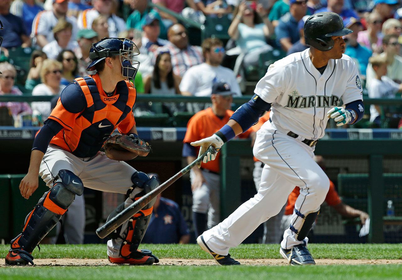 The Mariners’ Robinson Cano (right) hits an RBI single as Astros catcher Jason Castro looks on in the sixth inning of a game Saturday in Seattle. The Mariners’ Leonys Martin scored on the play. (AP Photo/Ted S. Warren)