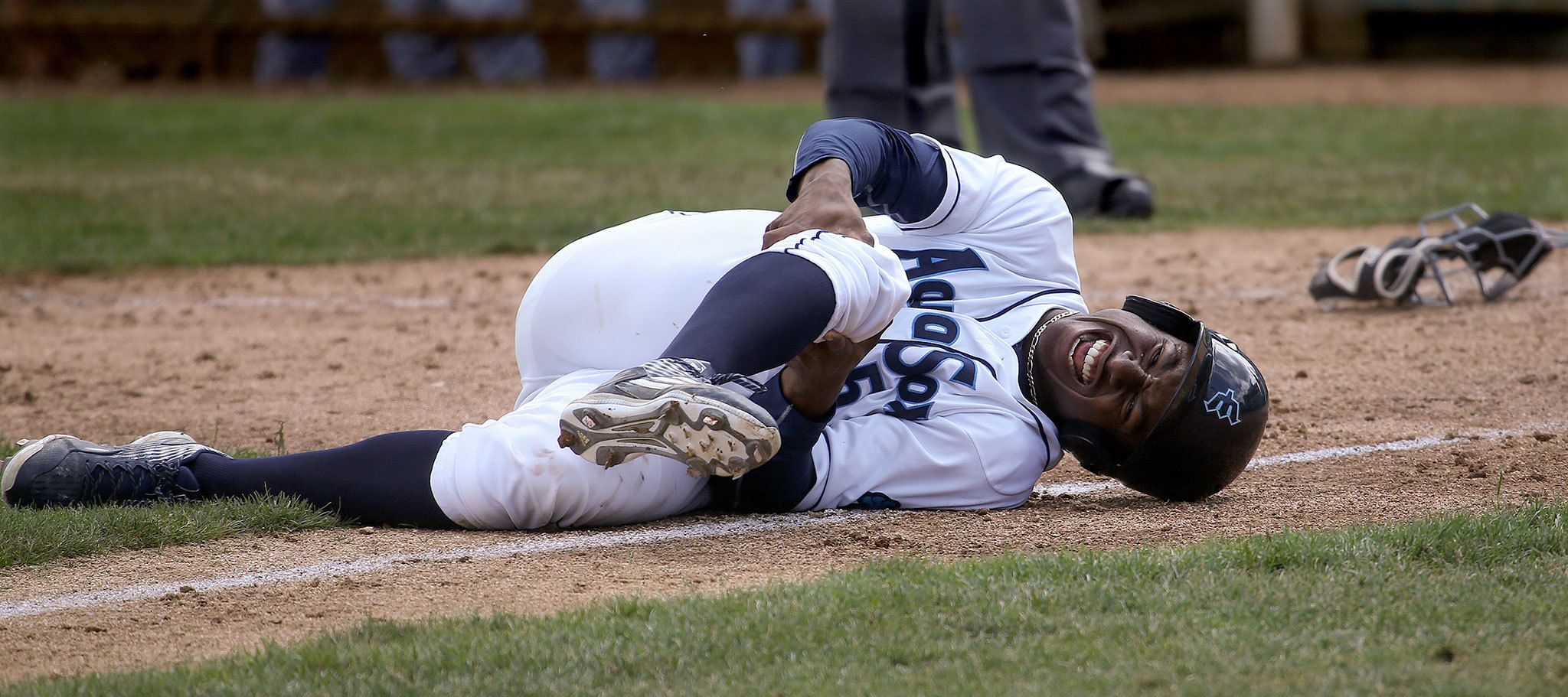 The AquaSox’s Kyle Lewis grabs his right knee after colliding with Dust Devils catcher Chris Mattison in Everett’s 8-6 loss to Tri-City on Tuesday at Everett Memorial Stadium. Lewis, the Mariner’s No. 1 draft pick, did not return to the game. (Andy Bronson / The Herald )