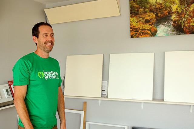 Heating Green owner Jeff Caldwell stands next to infrared heating panels​ at his Bellingham business. Heating Green has focused much of its efforts selling the infrared panels to hot yoga studios​. (Emily Hamann | BBJ)