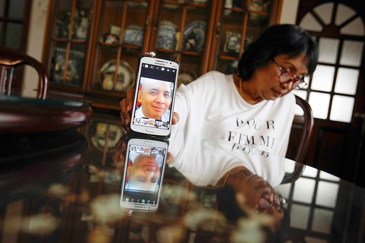 Sakinab Shah, sister of Capt. Zaharie Ahmad Shah, holds up a phone with a picture of her brother in Kuala Lumpur, Malaysia, on Feb. 28. (AP Photo/Joshua Paul)