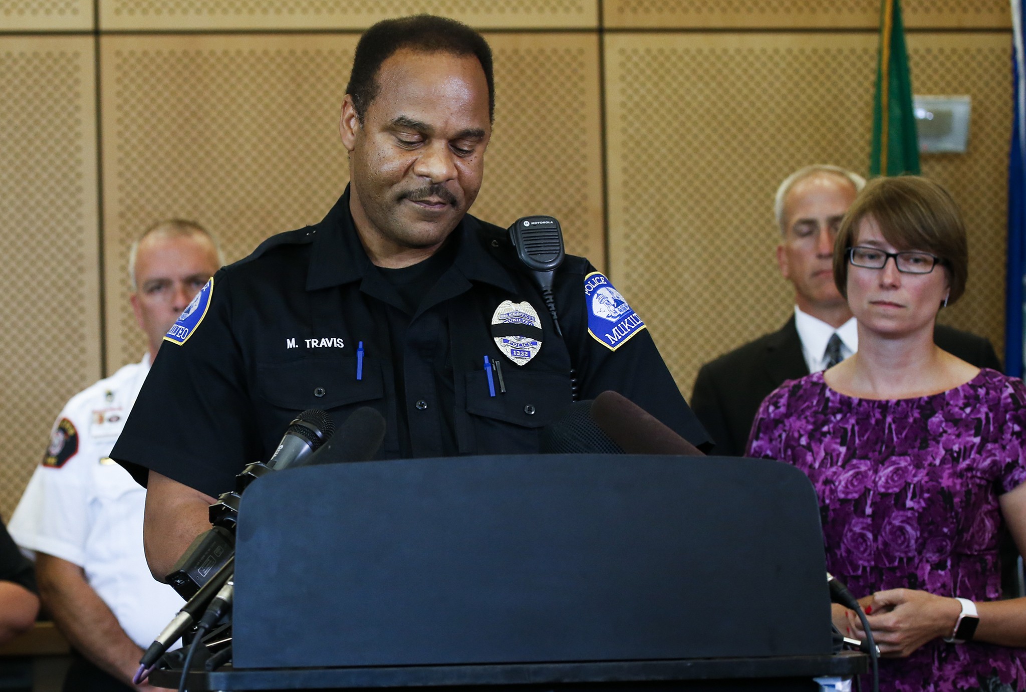 Mukilteo police officer Myron Travis addresses media as Mukilteo Mayor Jennifer Gregerson (right) stands by during a press conference held at Mukilteo City Hall on Saturday afternooon. Three were killed and one was injured following a shooting that occurred early Saturday morning at a home in the Chennault Beach area. (Ian Terry / The Herald)