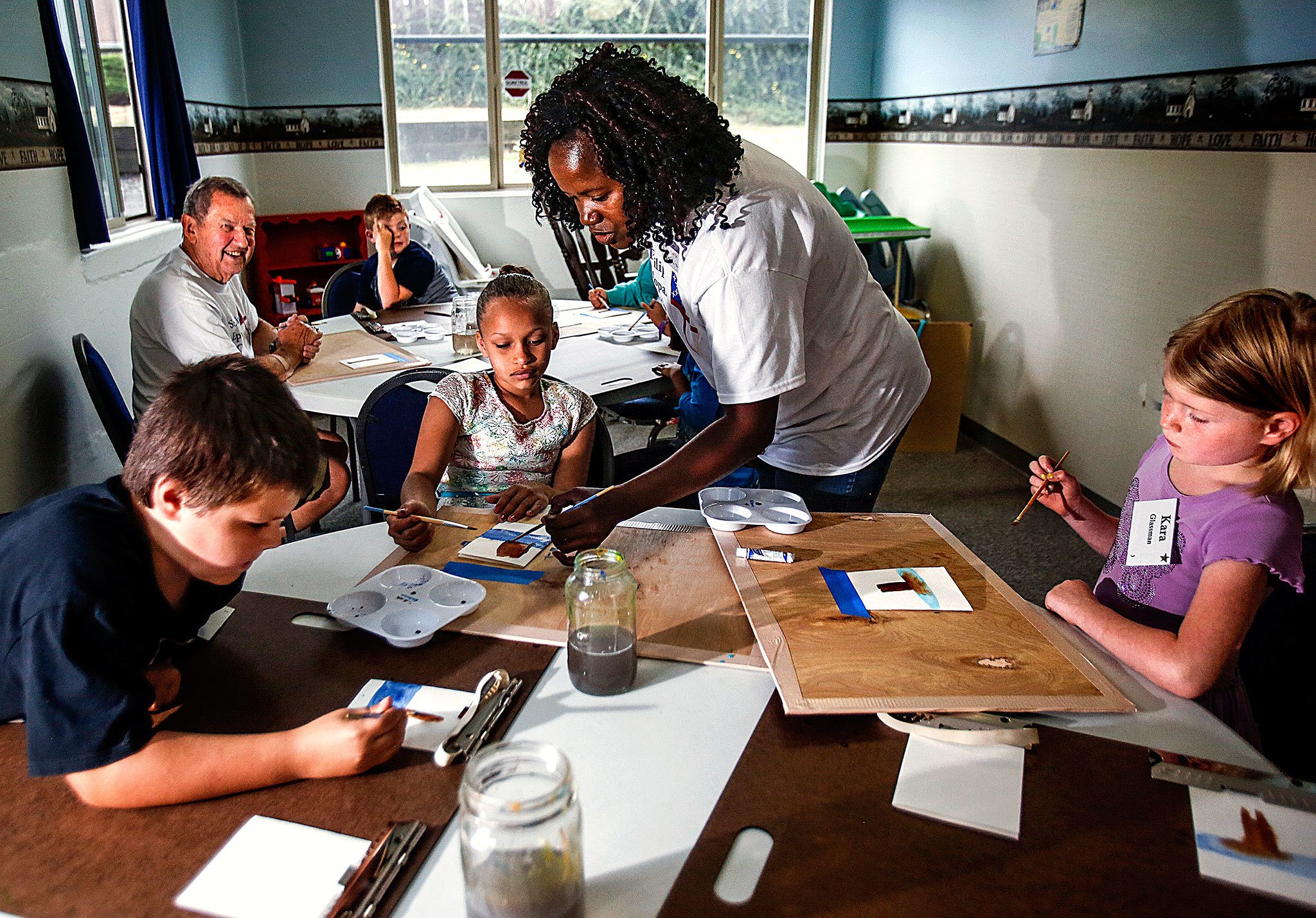 Art teacher Aletha Tatge (center) instructs Tylynne Smith and a dozen or more other first- and second-grade children who are attending summer school at St. Philip’s Episcopal Church in Marysville. Subjects taught include age math, reading, Spanish, music and art. (Dan Bates / The Herald)