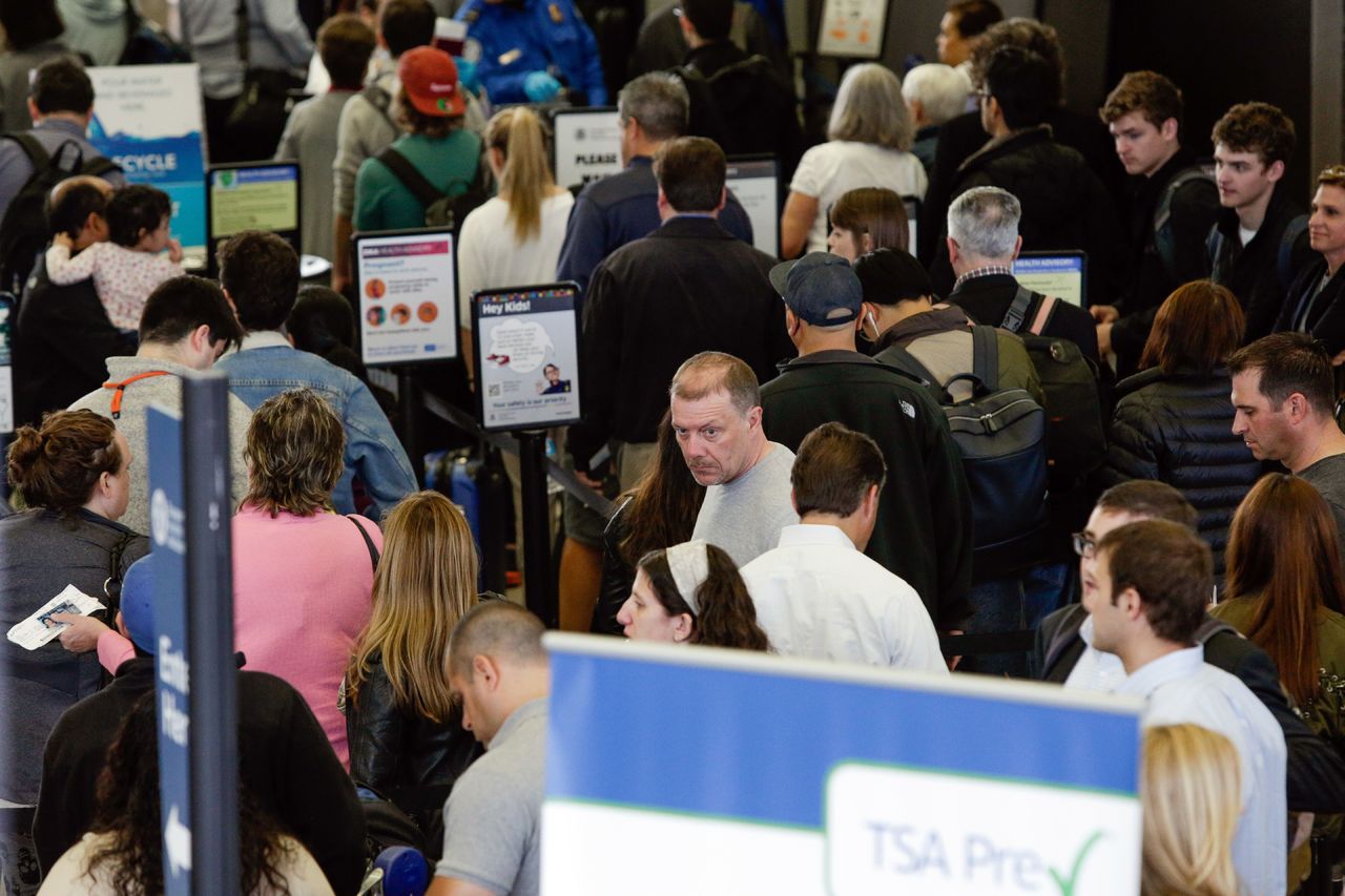 Travelers stand in line Monday to go through the TSA security checkpoint at O’Hare International airport in Chicago.
