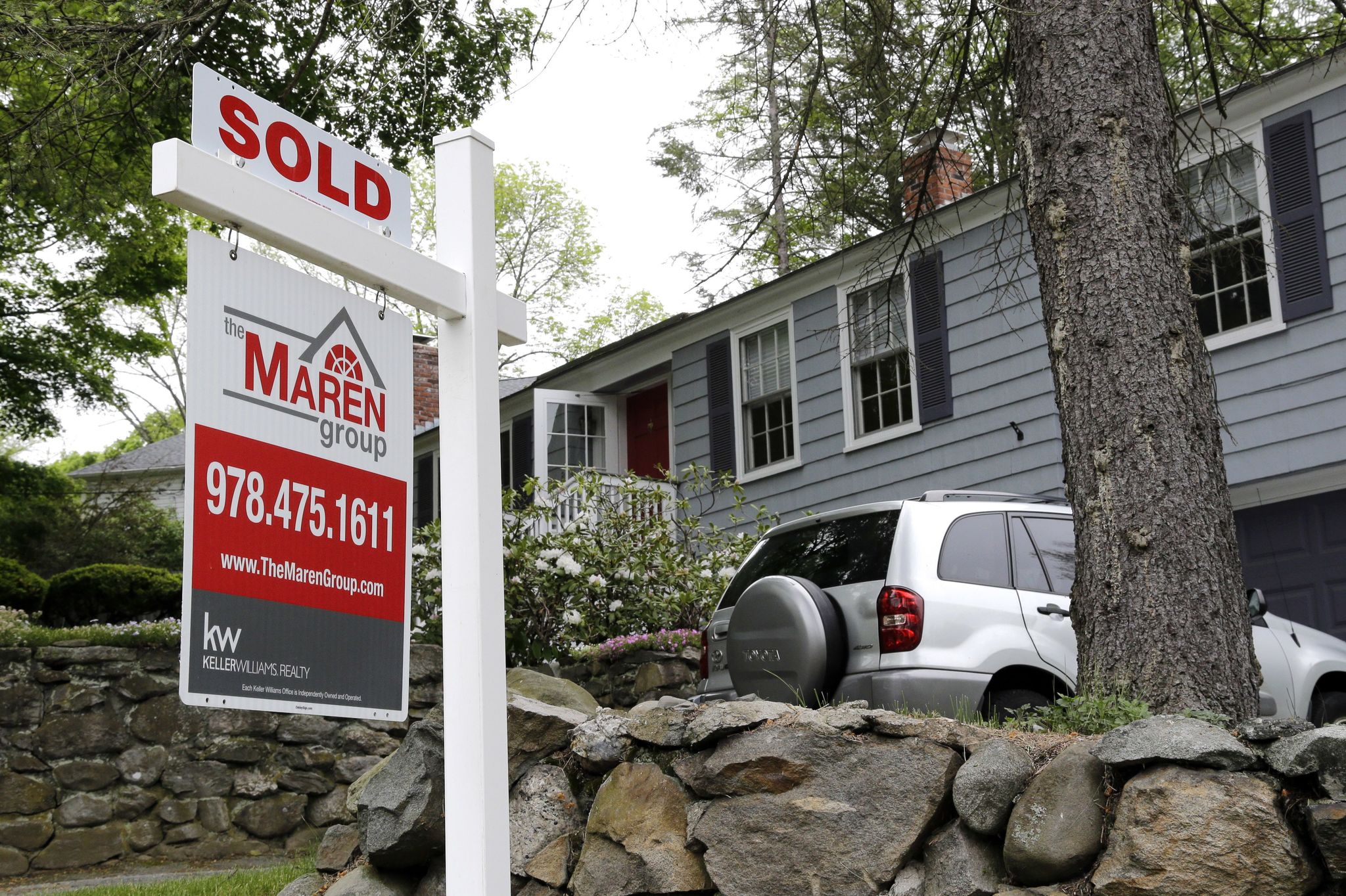 This May 24 photo shows a “Sold” sign in front of a house in Andover, Massachusetts.