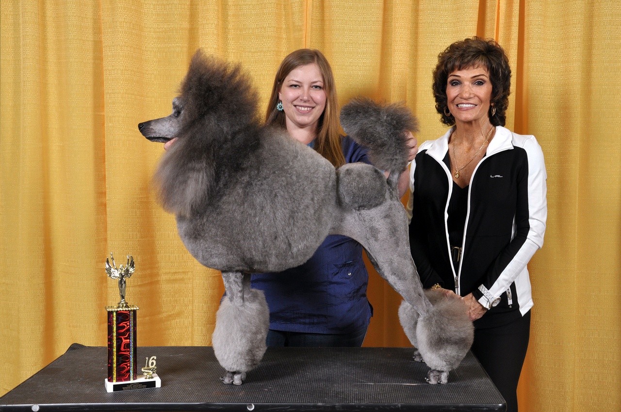 Edmonds pet groomer Zoe Zimmer (center) stands with her poodle Zora.