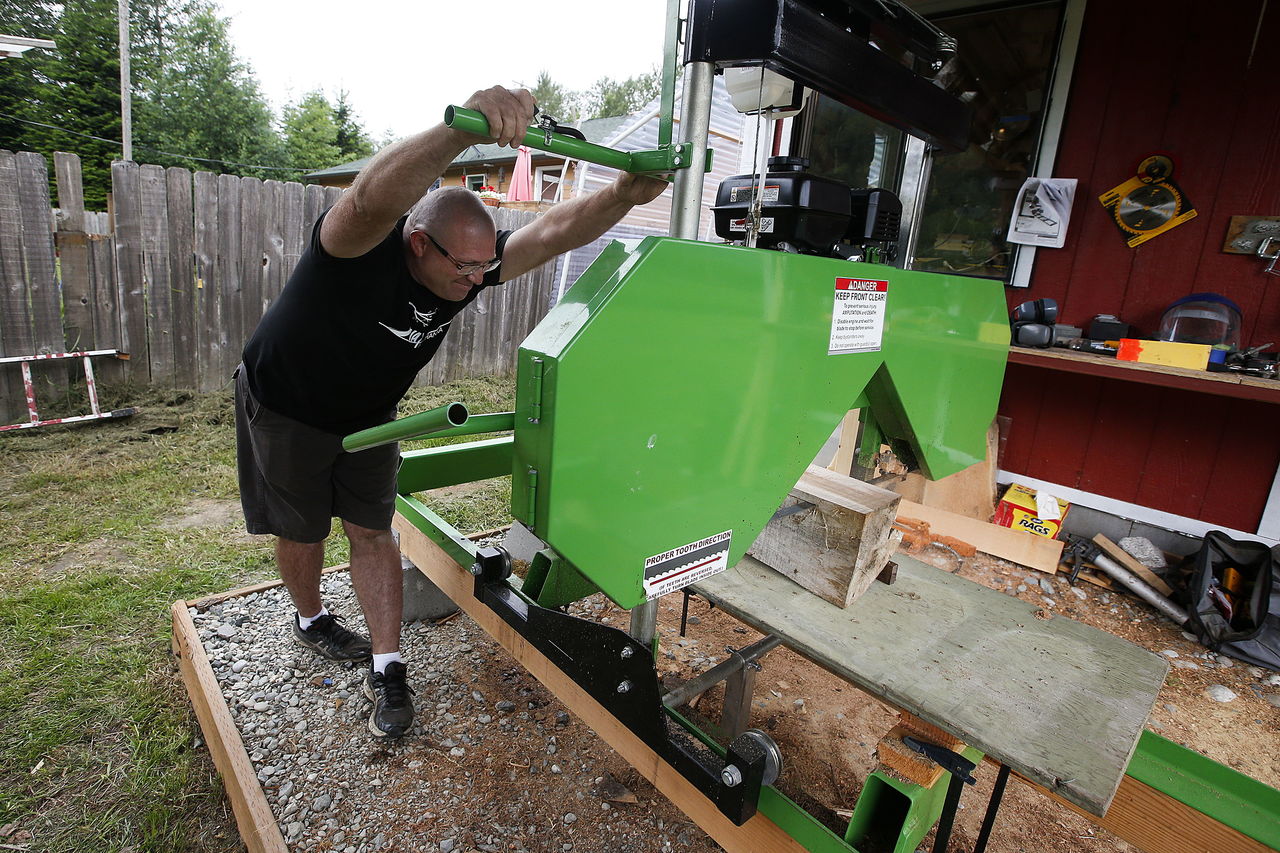 Mark Hanna pushes a saw through a piece of quilted maple.