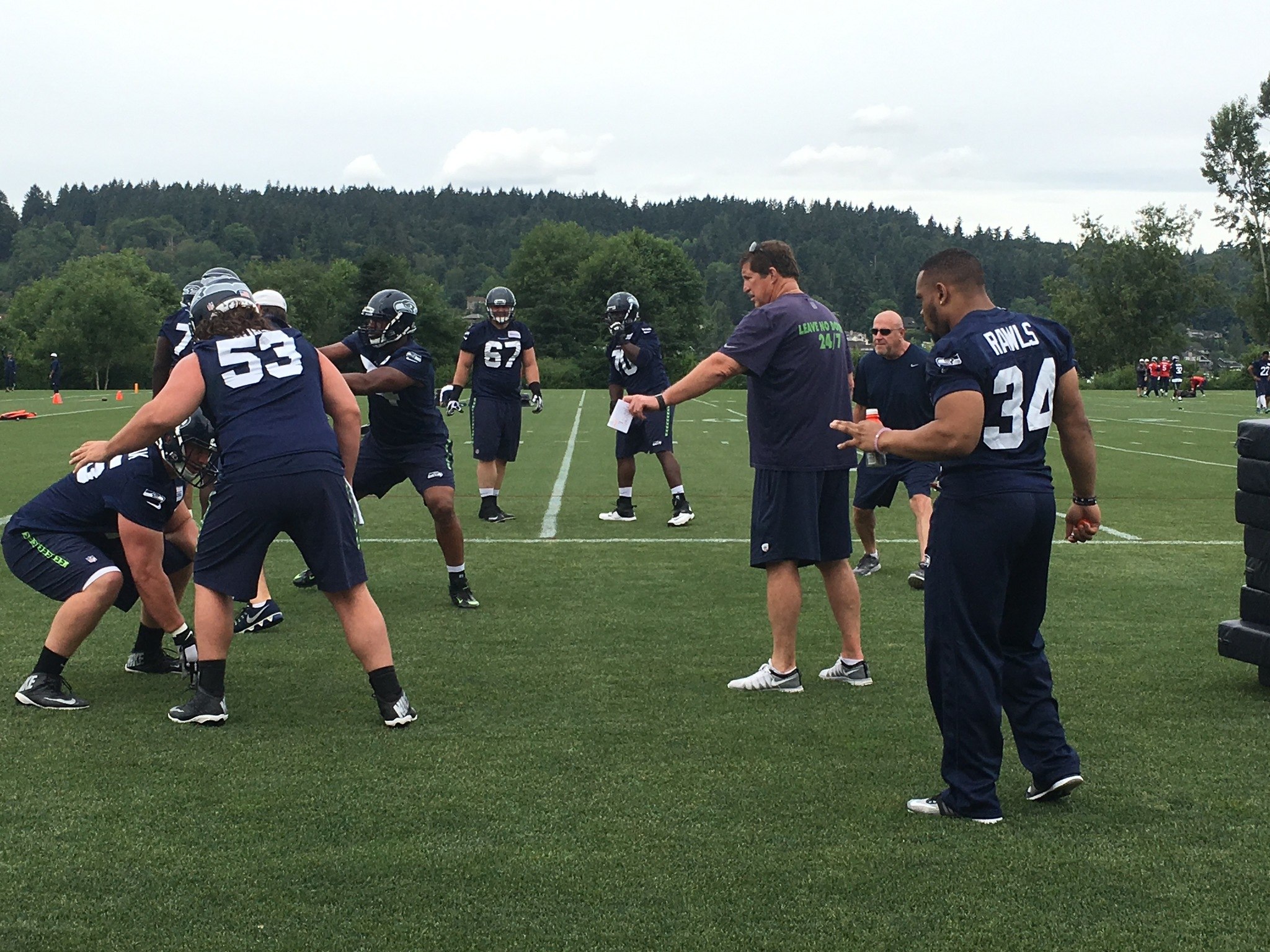 Running back Thomas Rawls (34), who is still recovering from an ankle injury, observes as the Seahawks put the offensive line through the paces at Thursday’s OTA.