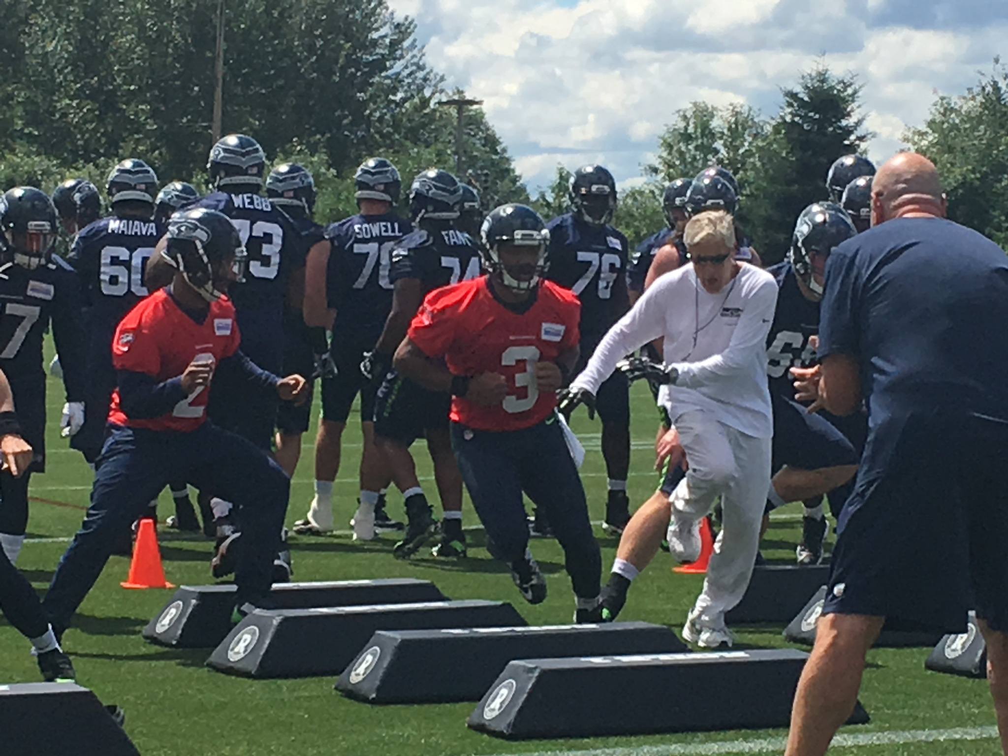 Seahawks coach Pete Carroll gets in step with quarterback Russell Wilson during the second day of Seattle’s minicamp Wednesday at the Virginia Mason Athletic Center.