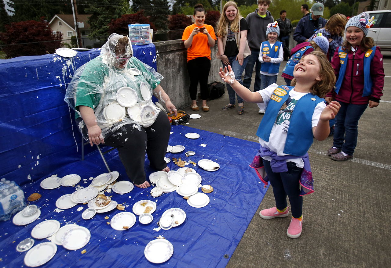 Rian Dowell, 7, celebrates a good whipped cream pie toss Thursday, while Scout leader Tina Fish remains a very good sport.
