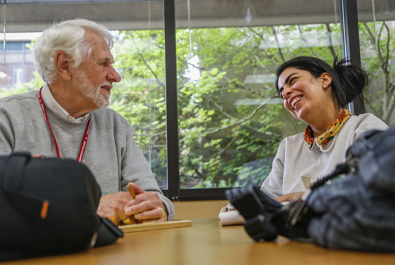 Curt Smith, a volunteer with EvCC’s Literacy Program, shares in a lighter moment while tutoring Sepideh Khazeei on Tuesday in Rainier Hall on the campus of Everett Community College.