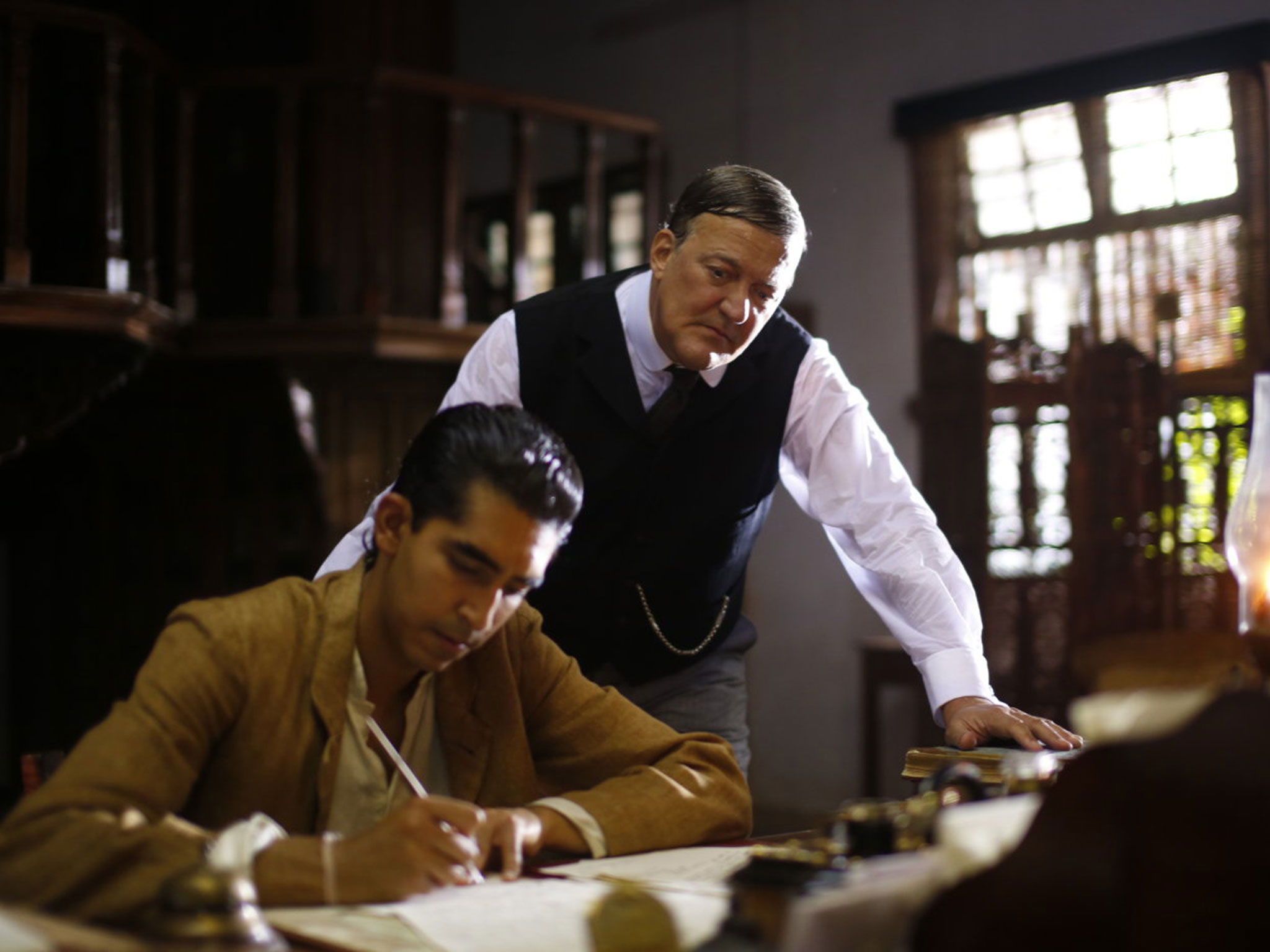 Dev Patel (left) dazzles Stephen Fry with his math genius in “The Man Who Invented Infinity.”