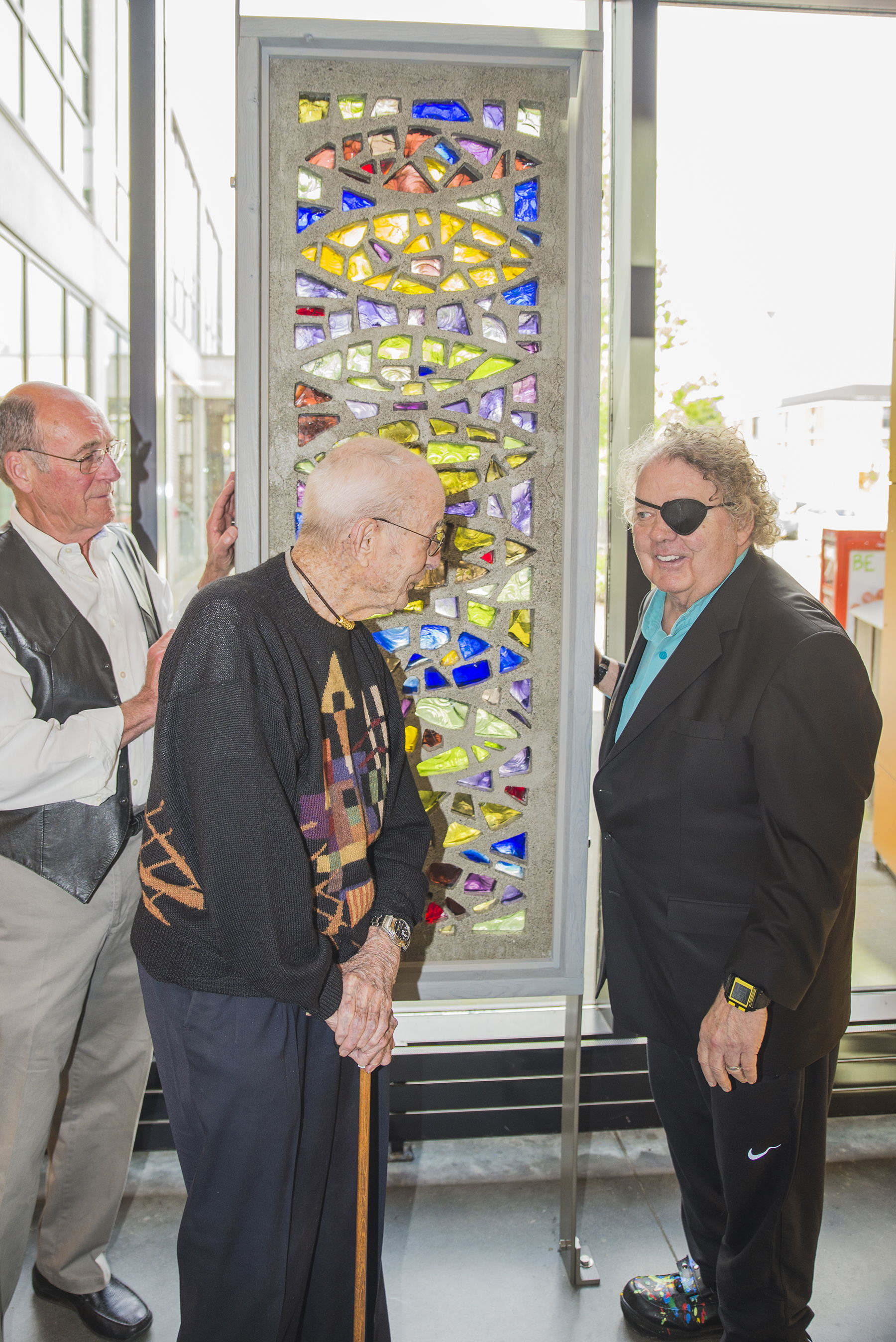 Former Everett Community College art instructor Russell Day (center) talks with glass sculptor Dale Chihuly (right) and retired art instructor Lowell Hanson (left), on Friday about his untitled 238-pound Blenko glass and concrete sculpture permanently installed in EvCC’s Whitehorse Hall.
