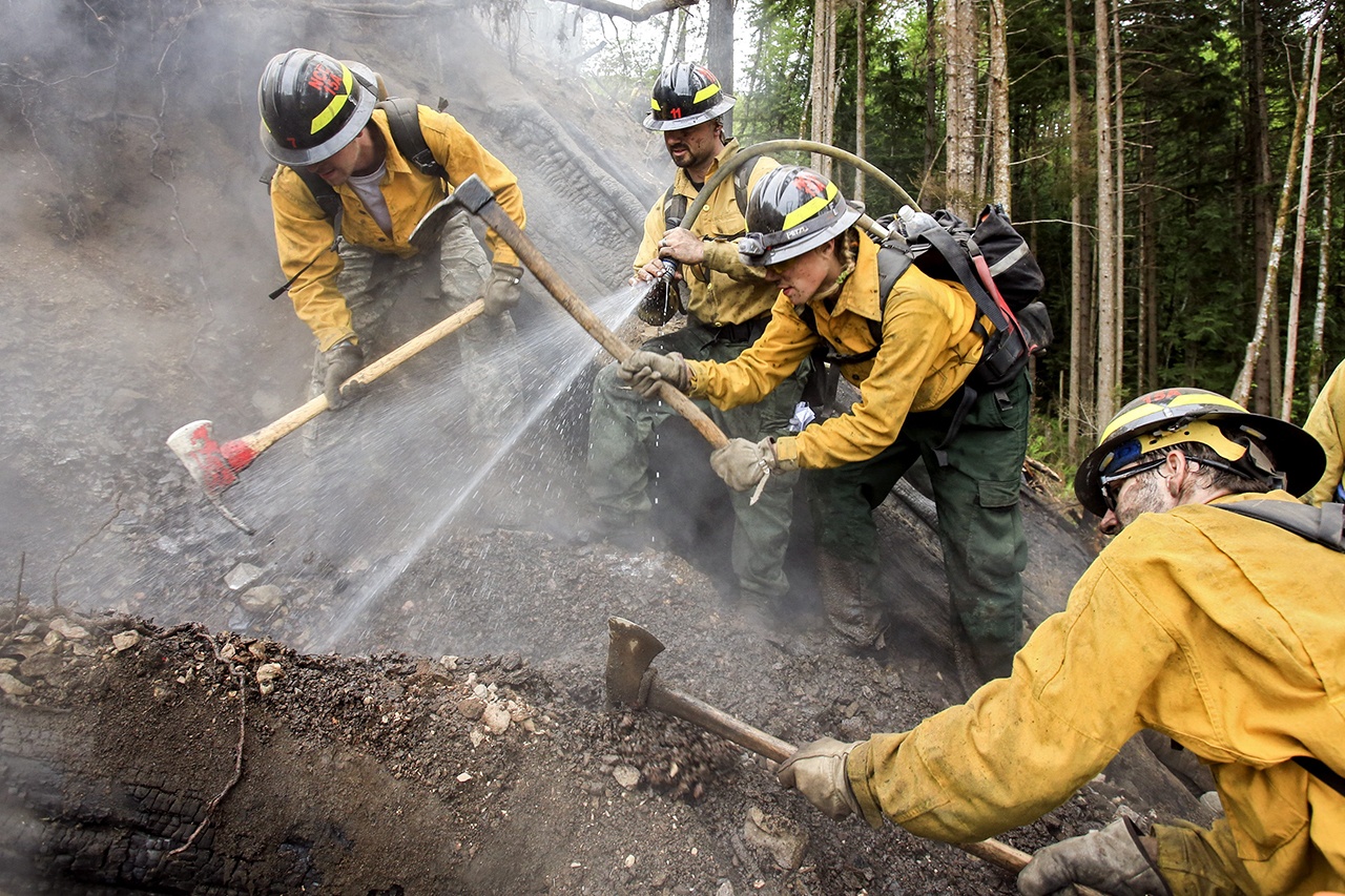 Wes Atwood (L-R) Branden Campbell, Shayla Adkins and Joshua Scott work to put out a hot spot at the scene of the Hot Shot fire outside Oso on May 18 of this year. (Kevin Clark / The Daily Herald, file)