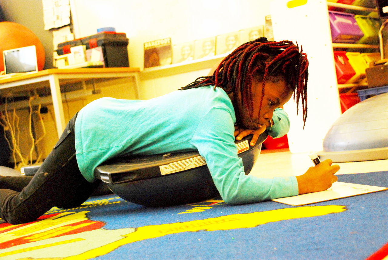 Flipping her BOSU upside down, Madina Kante works on a writing assignment.