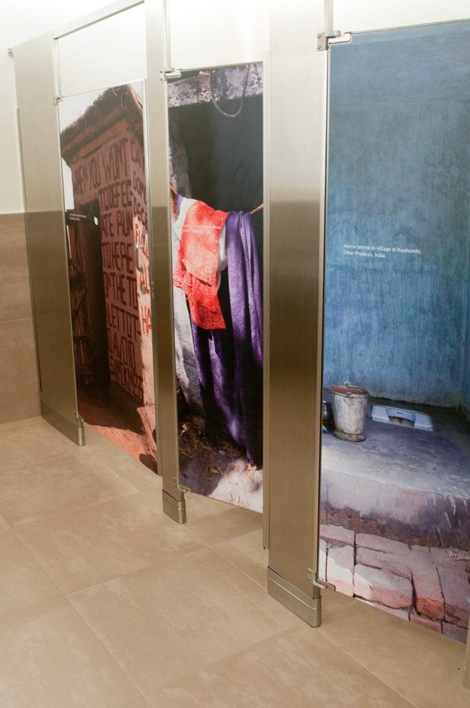 The stall doors in the women’s bathroom depict latrines used by millions of people in developing nations.
