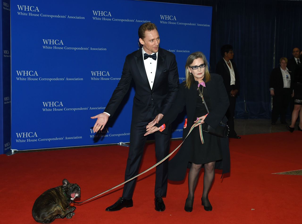 Tom Hiddleston, center, Carrie Fisher and her dog, Gary Fisher, arrive at the White House Correspondents’ Association Dinner in Washington in April.