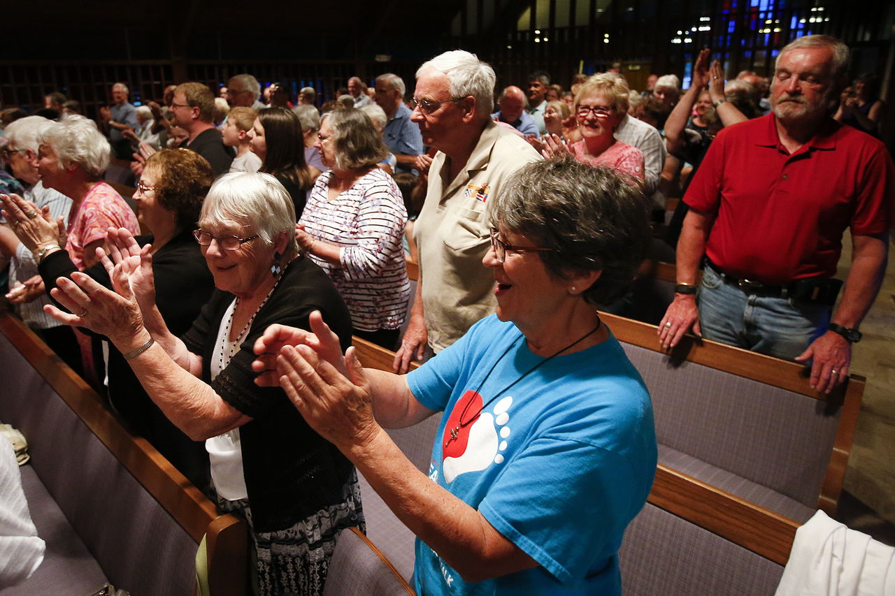 Audrey Kellerman (left) and Claudia Elliott (center) sing along during the Total Experience Gospel Choir’s performance. “I started at this church 35 years ago,” Elliott said, “I live in Leavenworth now and I came over just for this. It was worth it.”