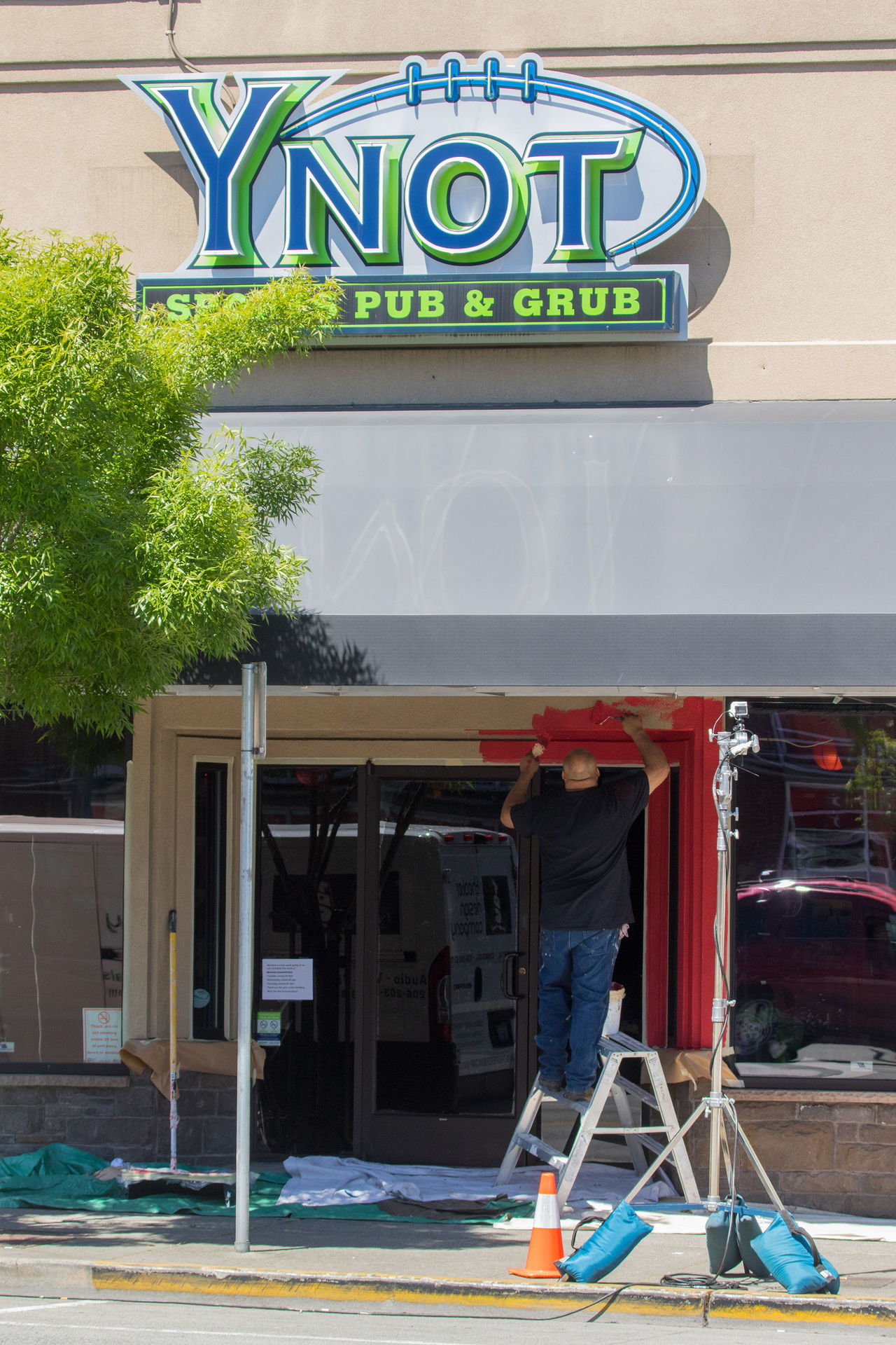 A man paints the outside at Ynot Sports Pub and Grub on Hewitt Avenue in Everett on Wednesday. A crew from the Spike TV show “Bar Rescue” is in town this week to remodel the bar for its TV show.